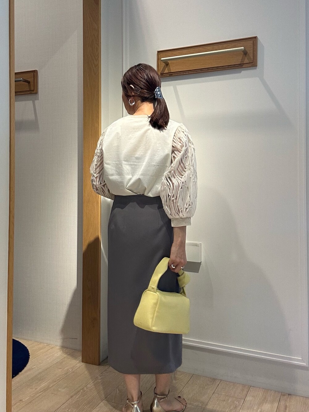 ホワイト系のTシャツ/カットソー、グレー系のスカート、イエロー系のショルダーバッグを着用したレディースの春コーディネートの2枚目の写真