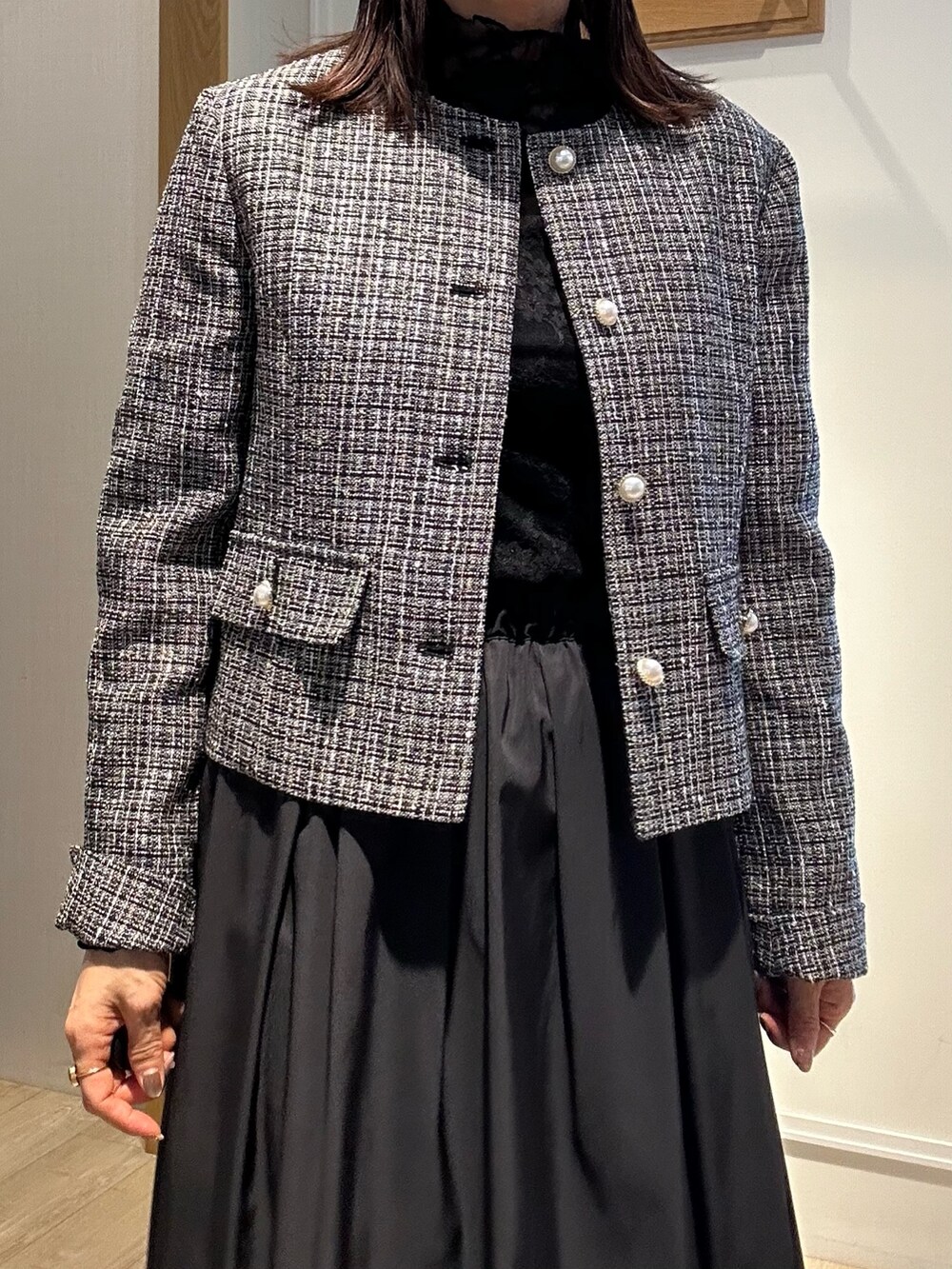 ブラック系のノーカラージャケット、ブラック系のTシャツ/カットソー、ブルー系のスカートを着用したレディースの冬コーディネートの9枚目の写真