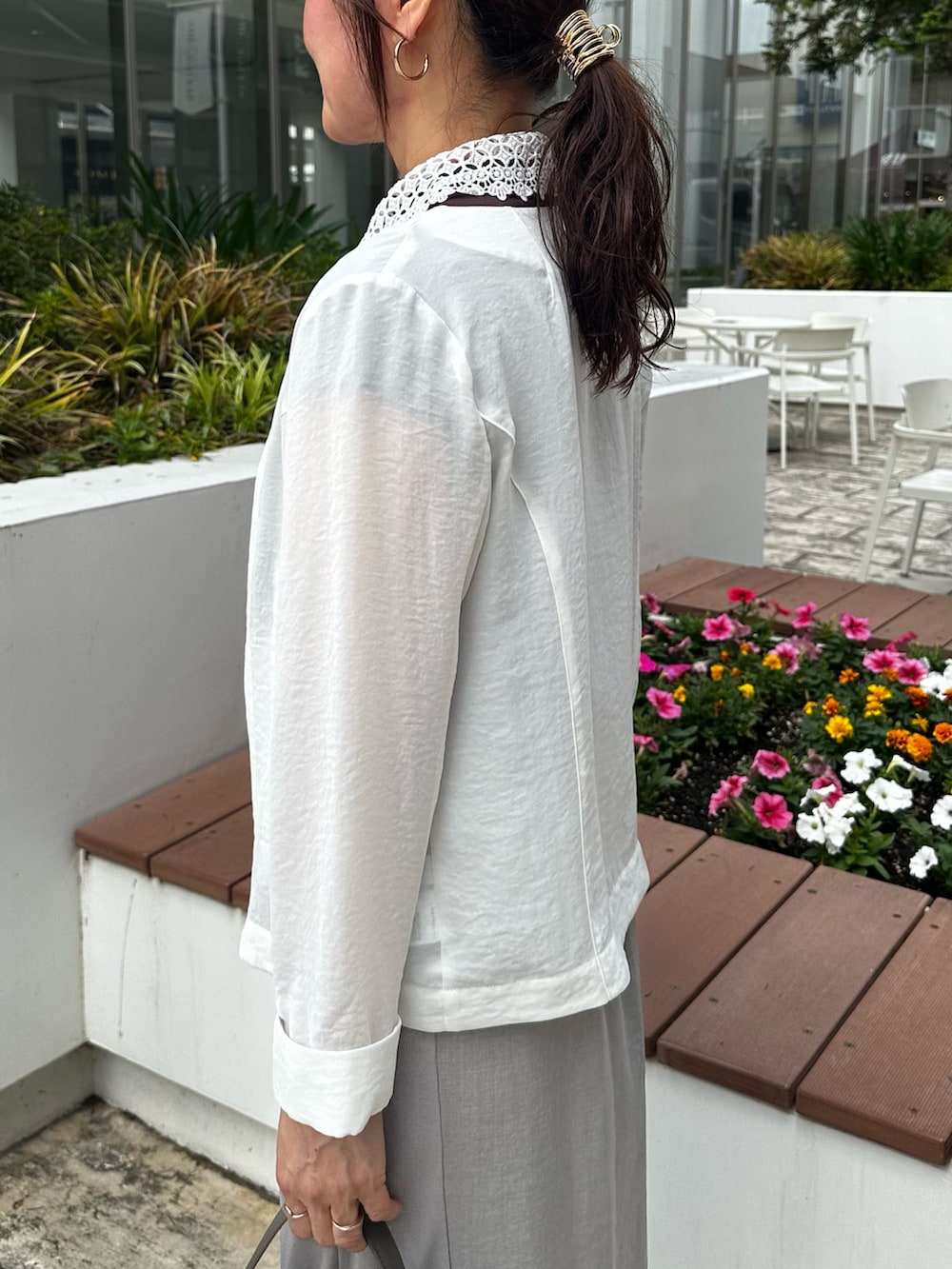 ホワイト系のノーカラージャケット、ブラウン系のTシャツ/カットソー、グレー系のスカートを着用したレディースの夏コーディネートの5枚目の写真