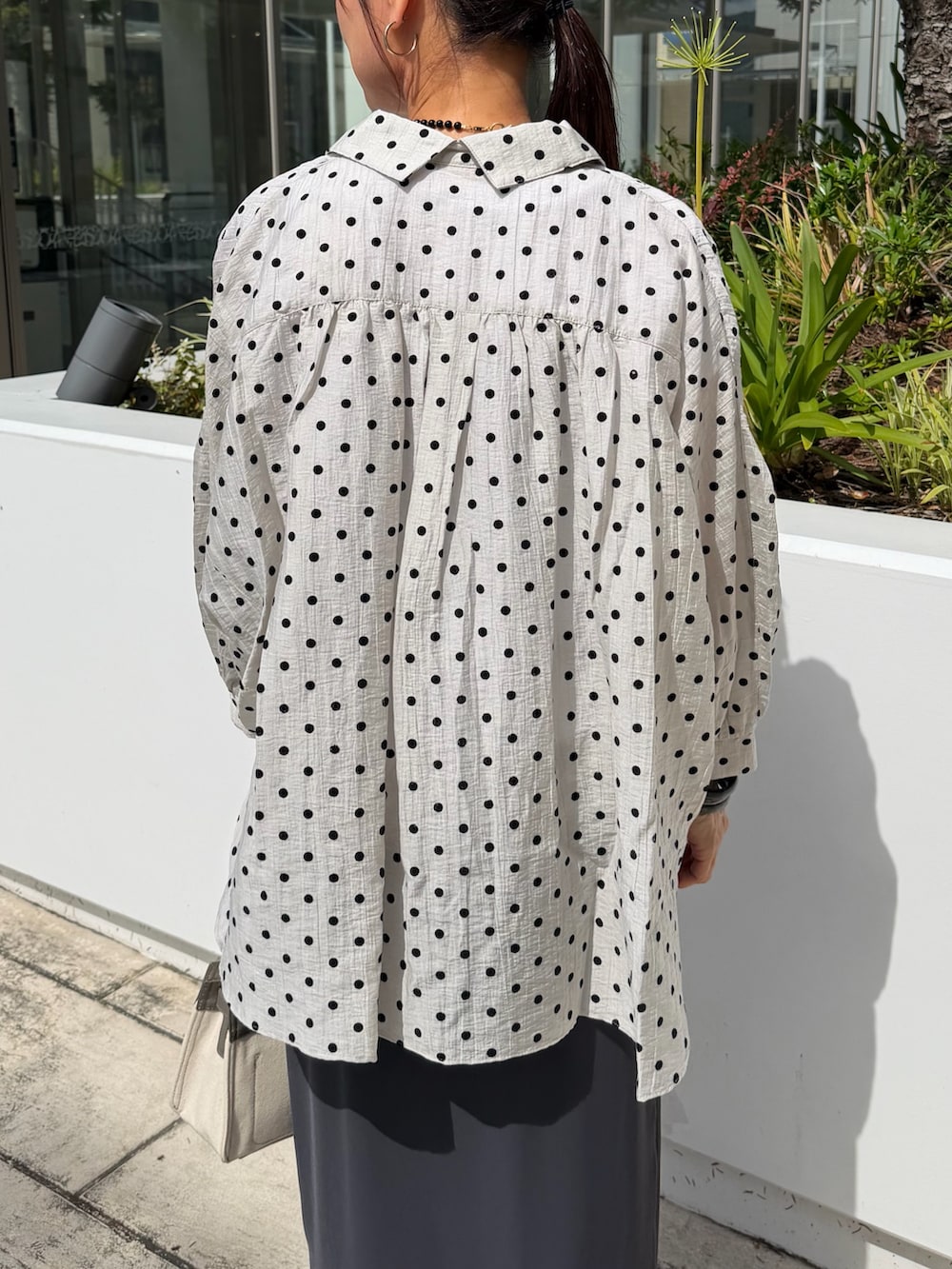 ホワイト系のTシャツ/カットソー、グレー系のスカート、ベージュ系のショルダーバッグを着用したレディースの夏コーディネートの6枚目の写真