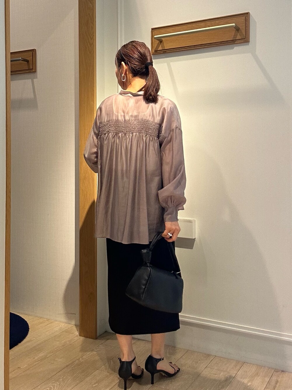 ホワイト系のTシャツ/カットソー、ブラック系のスカートを着用したレディースの春コーディネートの2枚目の写真