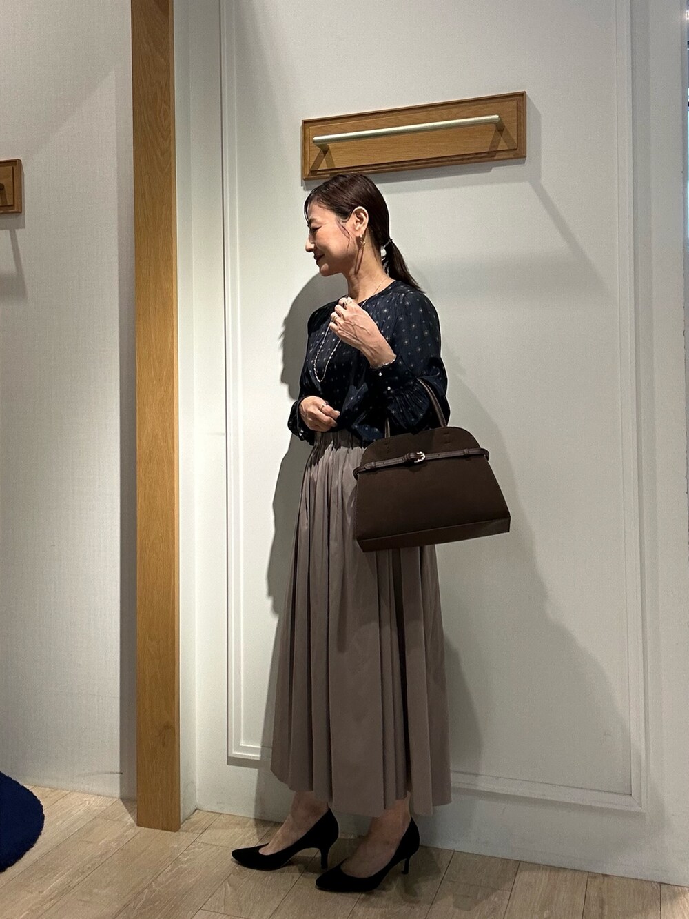 ブラウン系のスカート、ブルー系のシャツ/ブラウス、ブラウン系のトートバッグを着用したレディースの秋コーディネートの4枚目の写真