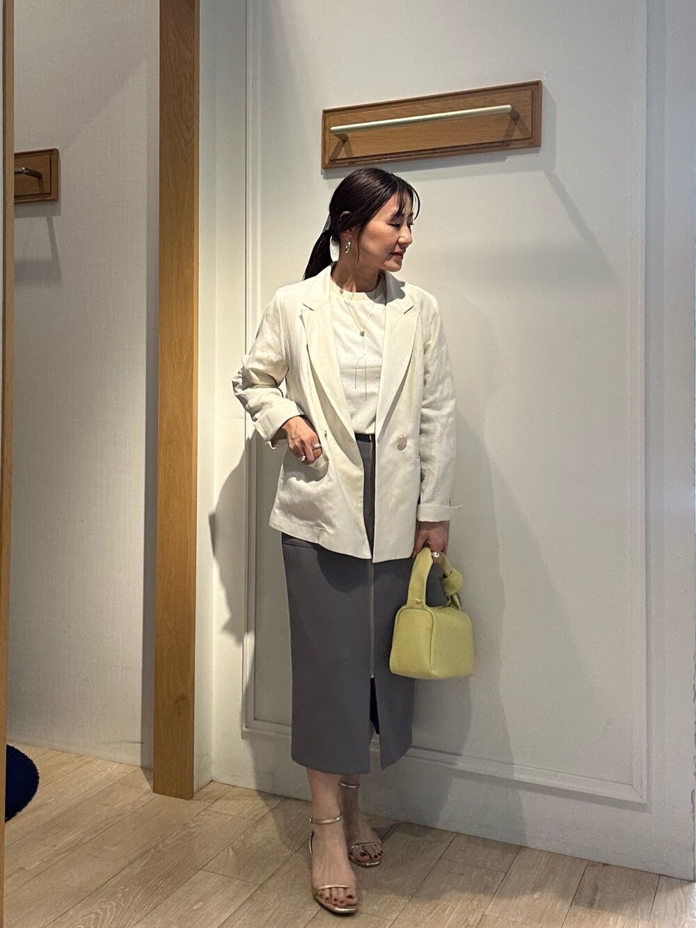 ホワイト系のテーラードジャケット、ホワイト系のTシャツ/カットソー、グレー系のスカートを着用したレディースの春コーディネートの2枚目の写真