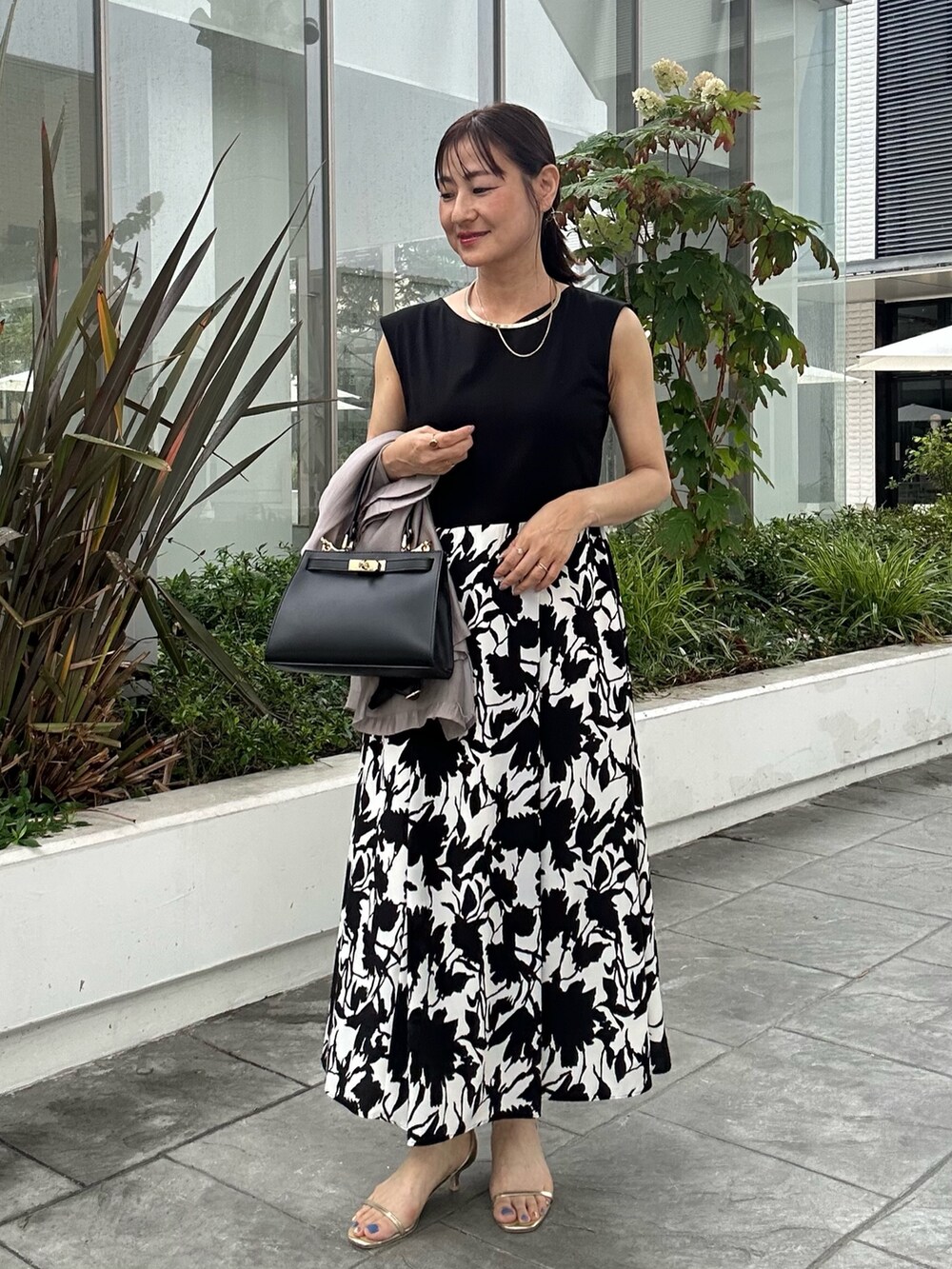 ホワイト系のワンピース、ブラック系のショルダーバッグ、ベージュ系のテーラードジャケットを着用したレディースの夏コーディネートの4枚目の写真