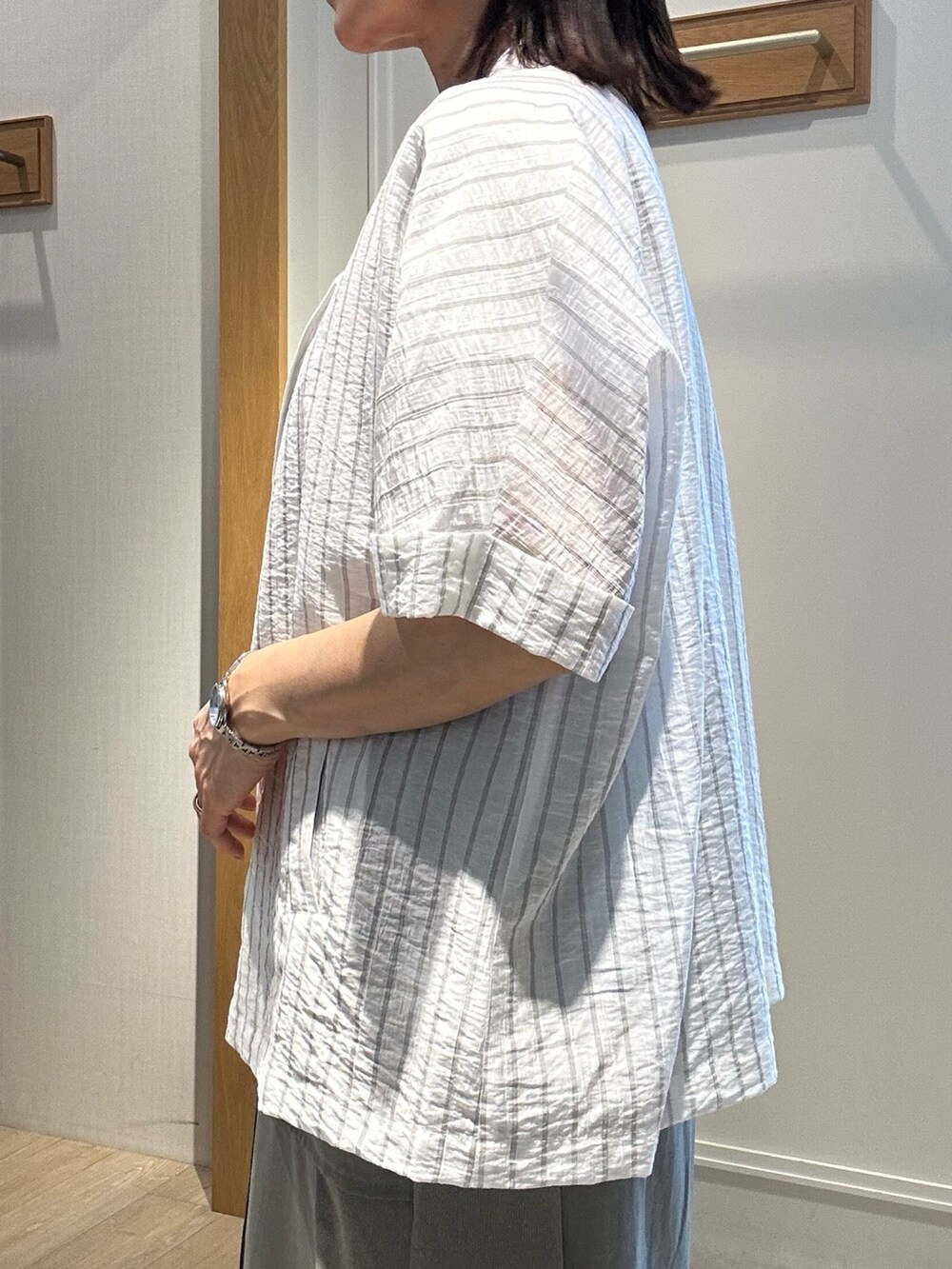 グレー系のテーラードジャケット、ホワイト系のTシャツ/カットソー、グリーン系のスカートを着用したレディースの夏コーディネートの6枚目の写真