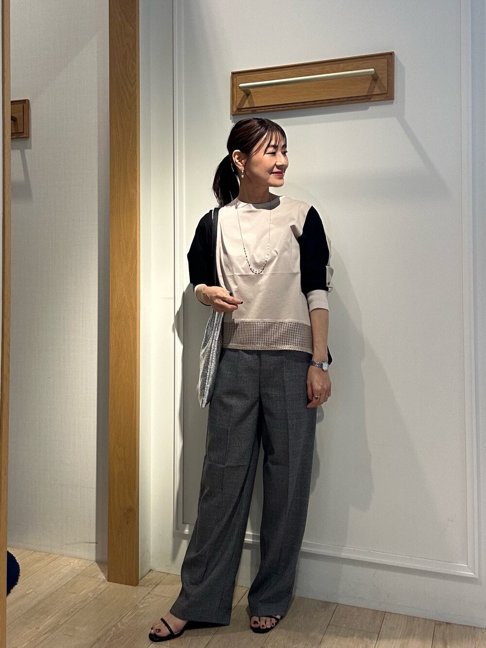ベージュ系のTシャツ/カットソー、グレー系のその他パンツ、ブラック系のサンダルを着用したレディースの秋コーディネートの4枚目の写真