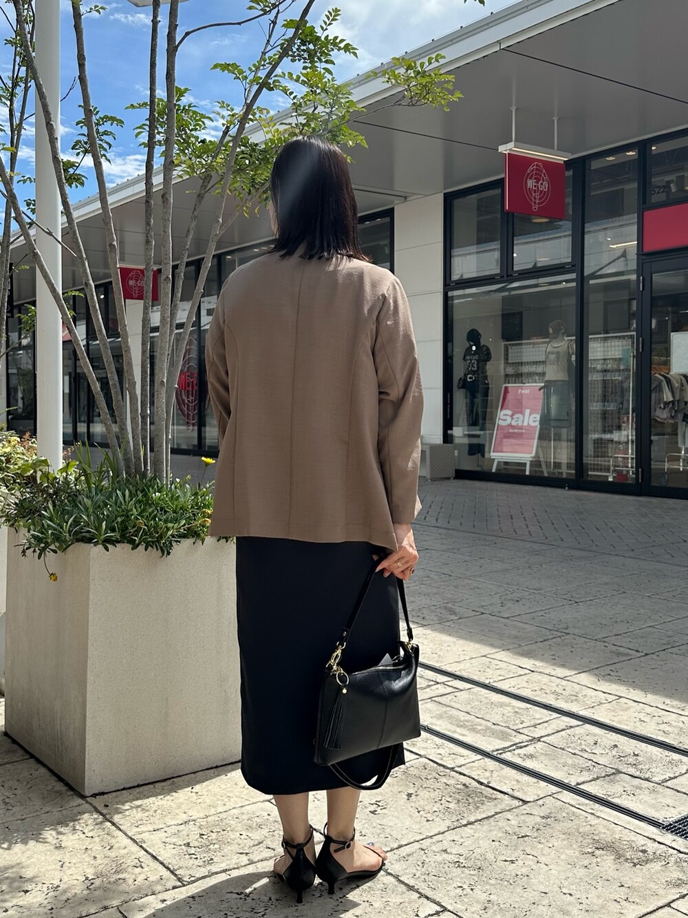 ブルー系のスカート、イエロー系のノーカラージャケット、ベージュ系のシャツ/ブラウスを着用したレディースの夏コーディネートの3枚目の写真
