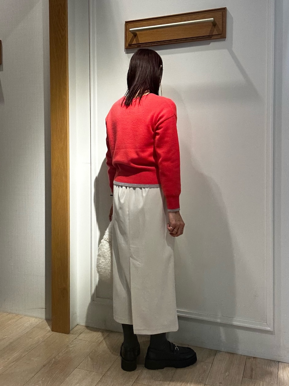 ピンク系のニット/セーター、ホワイト系のスカート、グレー系のダウンジャケット/コートを着用したレディースの冬コーディネートの3枚目の写真