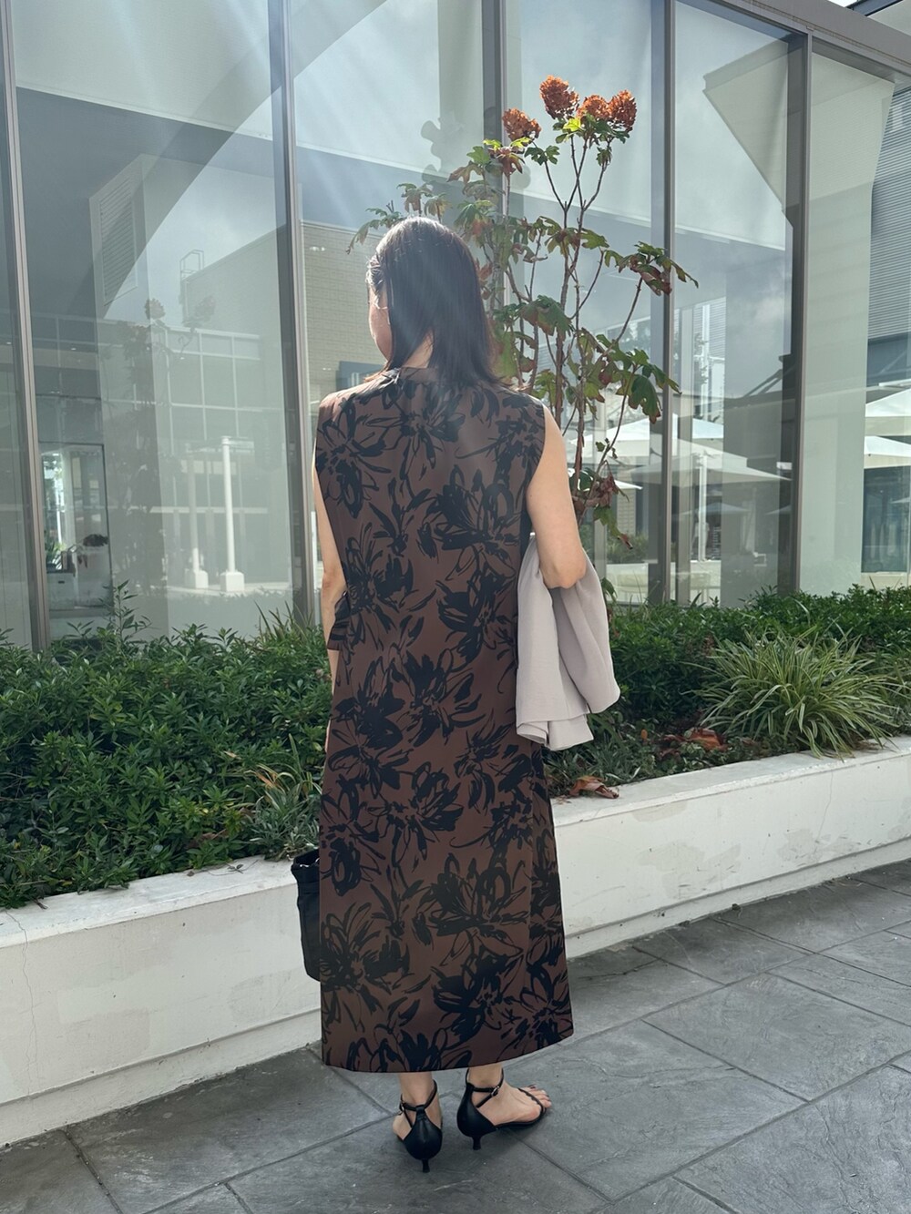 ベージュ系のワンピース、ブラック系のトートバッグ、ベージュ系のノーカラージャケットを着用したレディースの秋コーディネートの3枚目の写真