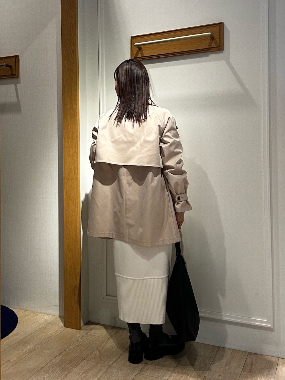 ベージュ系のその他アウター、ブラック系のニット/セーター、ホワイト系のスカートを着用したレディースの冬コーディネートの3枚目の写真