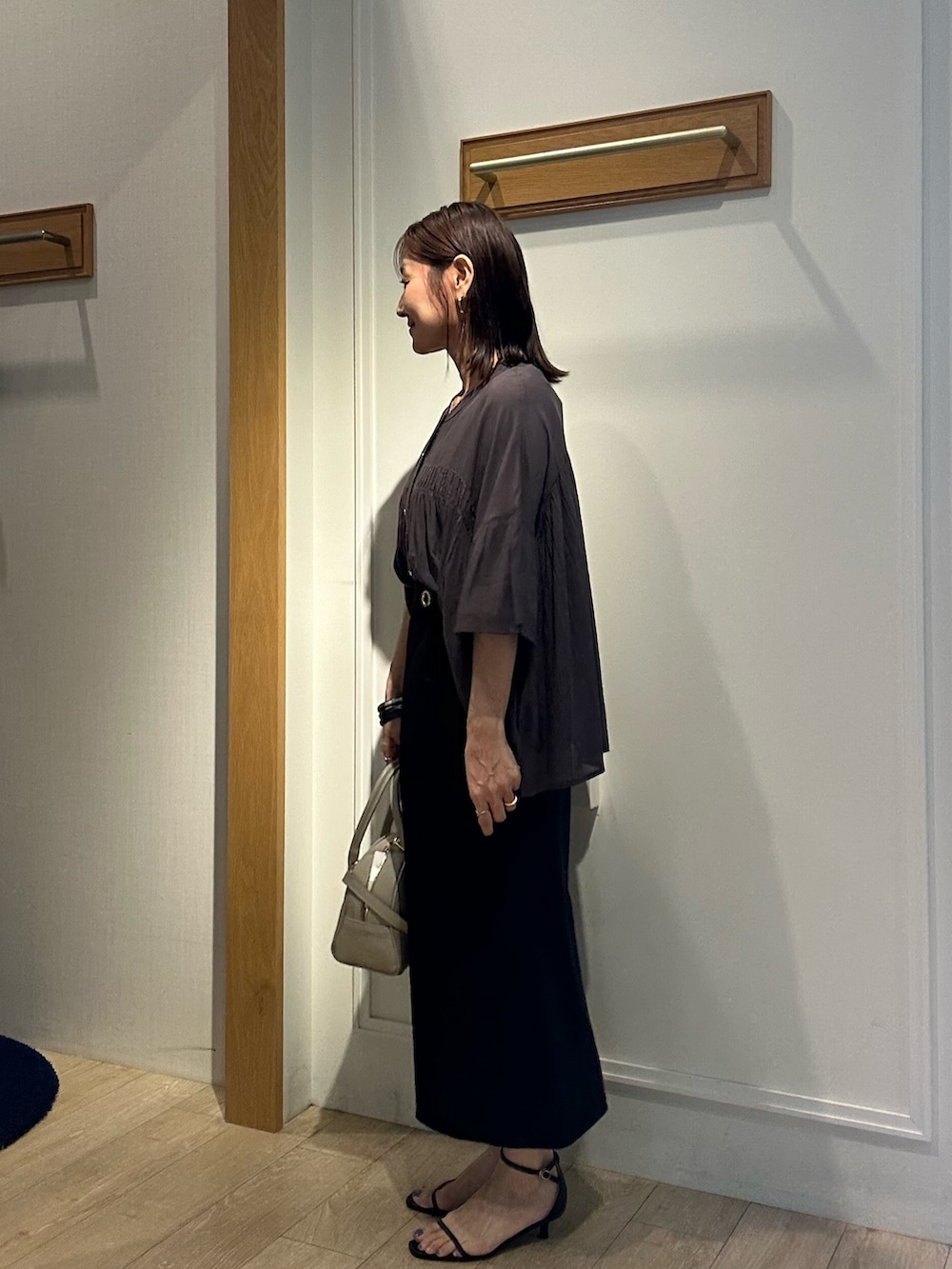 グレー系のシャツ/ブラウス、ブラック系のスカート、ベージュ系のボストンバッグを着用したレディースの夏コーディネートの3枚目の写真