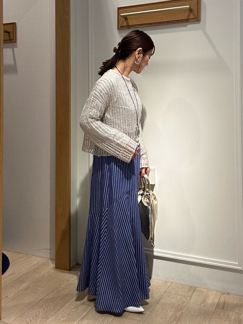 ベージュ系のニット/セーター、ホワイト系のTシャツ/カットソー、ゴールド系のショルダーバッグを着用したレディースの冬コーディネートの4枚目の写真