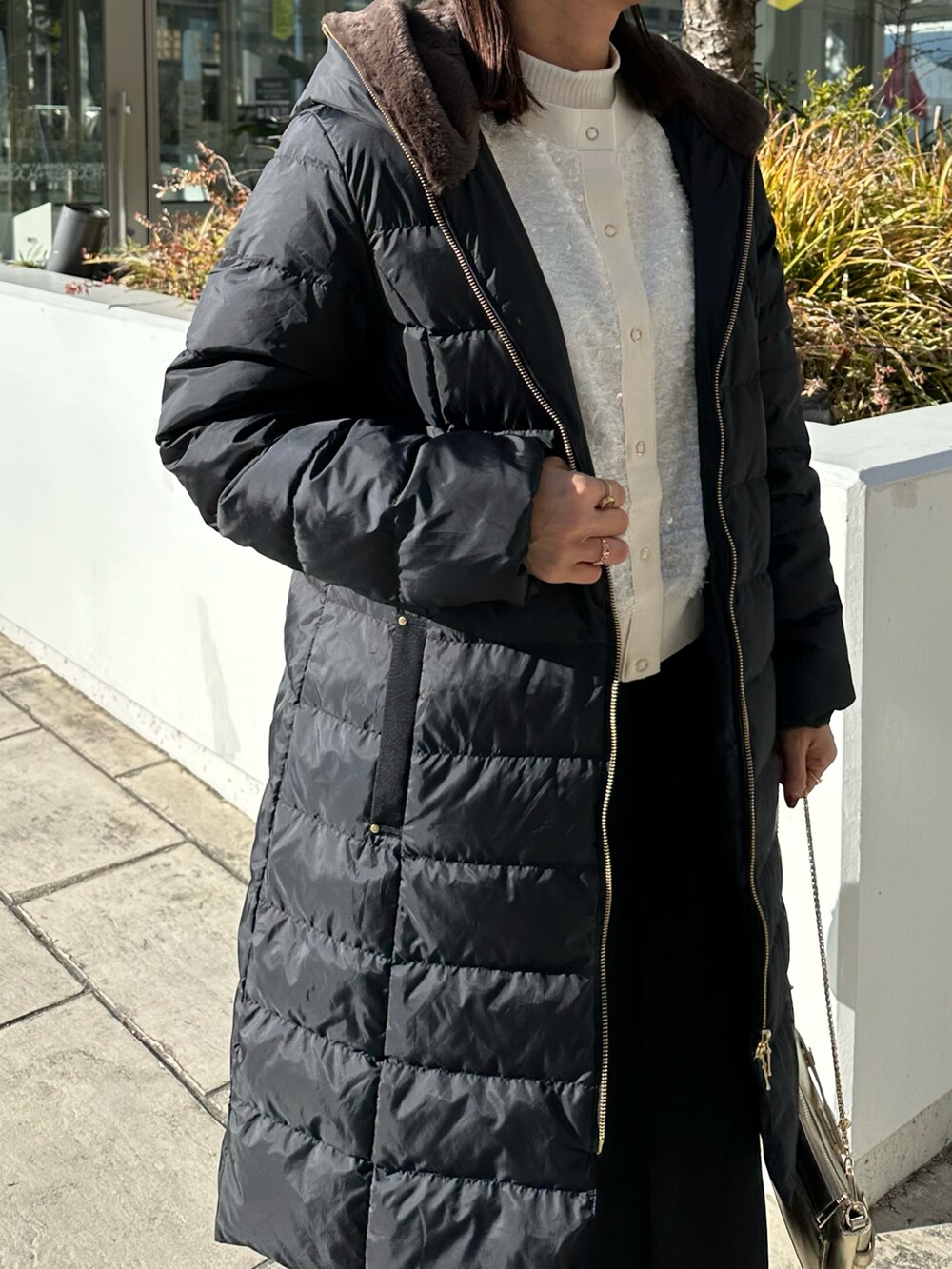 ブラック系のダウンジャケット/コート、ゴールド系のショルダーバッグを着用したレディースの冬コーディネートの4枚目の写真