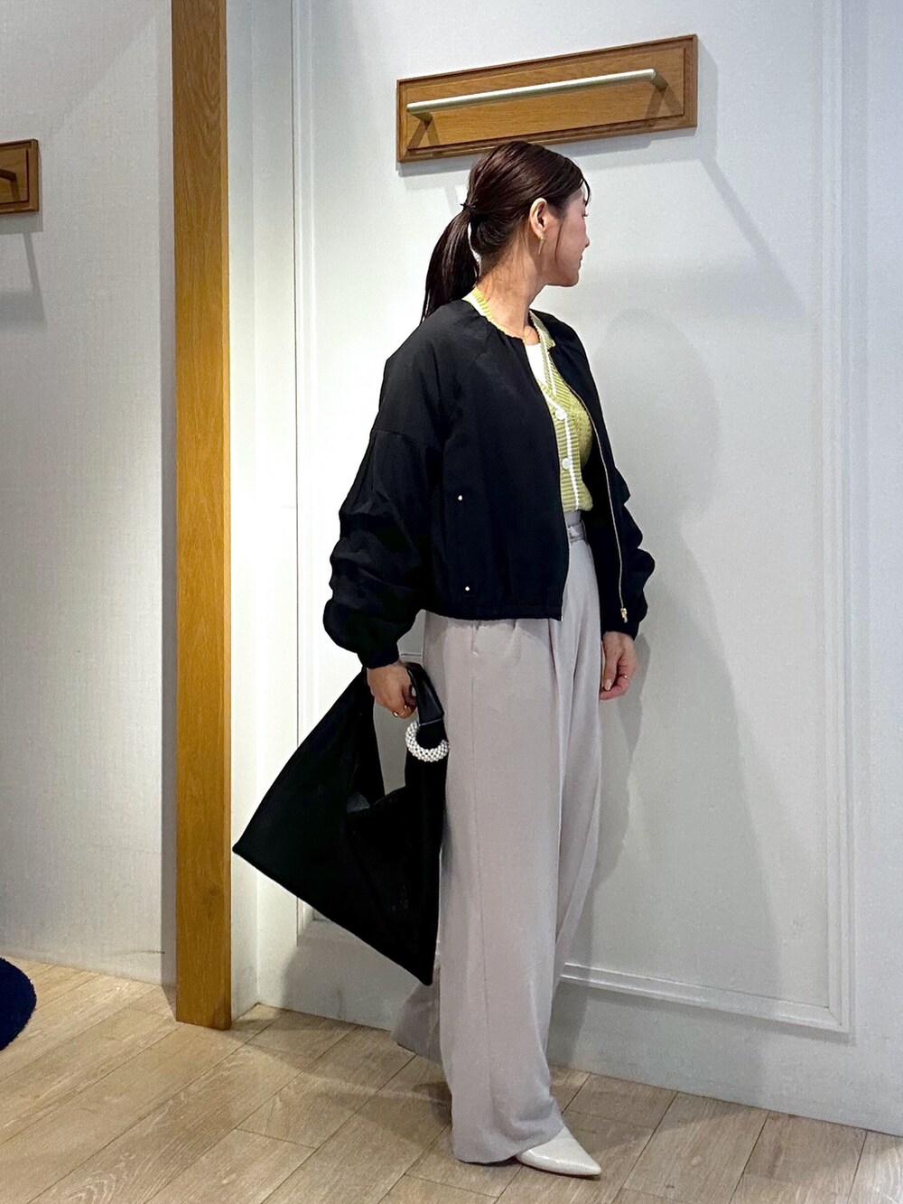 イエロー系のカーディガン/ボレロ、ホワイト系のTシャツ/カットソー、ベージュ系のその他パンツを着用したレディースの春コーディネートの9枚目の写真