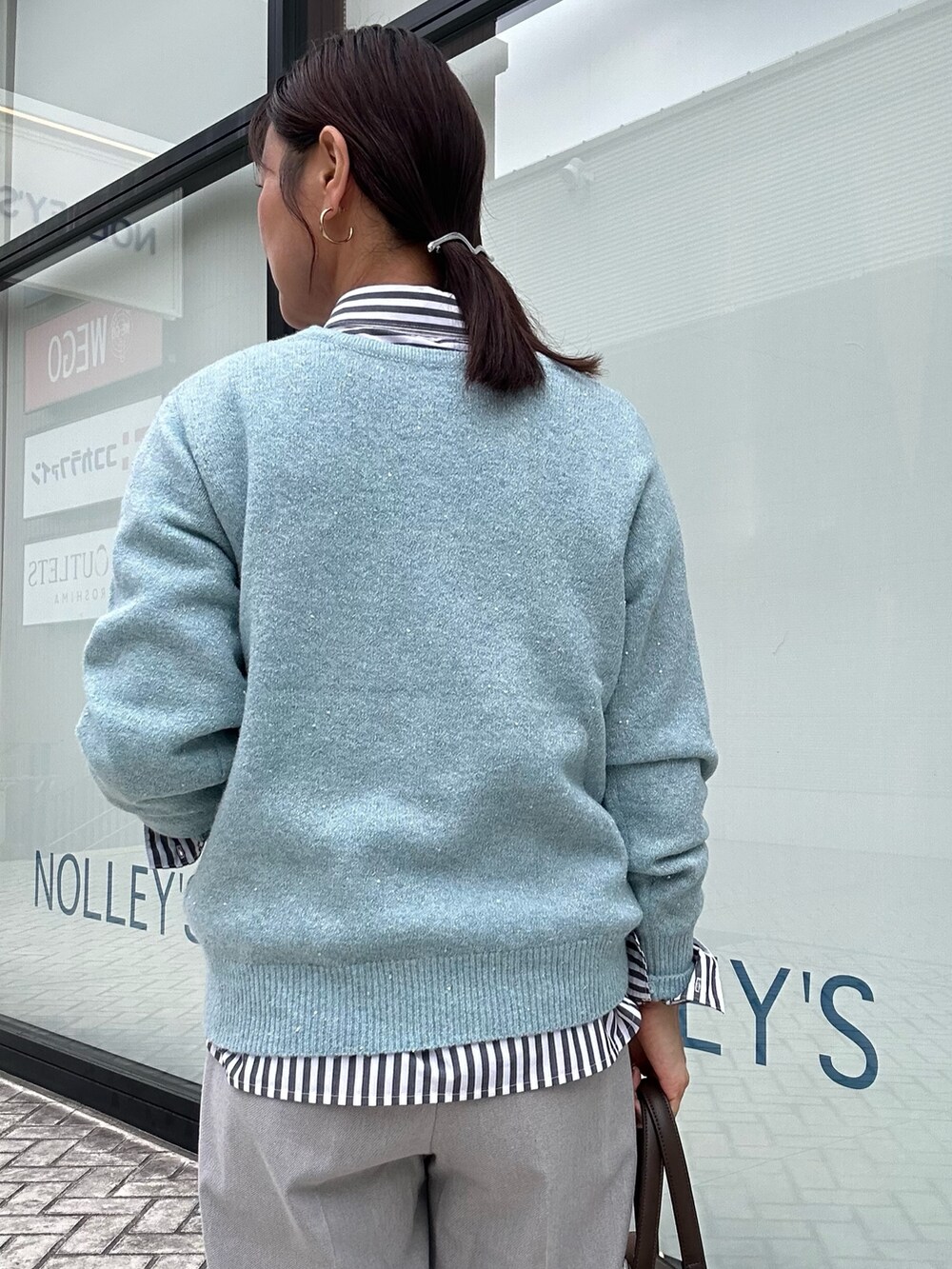 ブルー系のニット/セーター、グレー系のその他パンツ、ブラック系のシャツ/ブラウスを着用したレディースの秋コーディネートの8枚目の写真