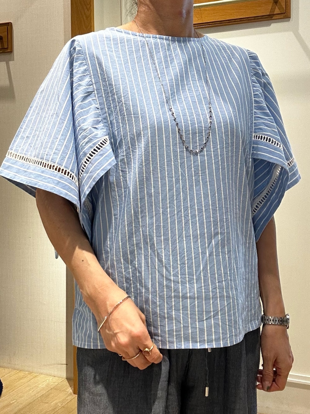 ブルー系のシャツ/ブラウス、ブルー系のデニムパンツ、シルバー系のトートバッグを着用したレディースの春コーディネートの5枚目の写真