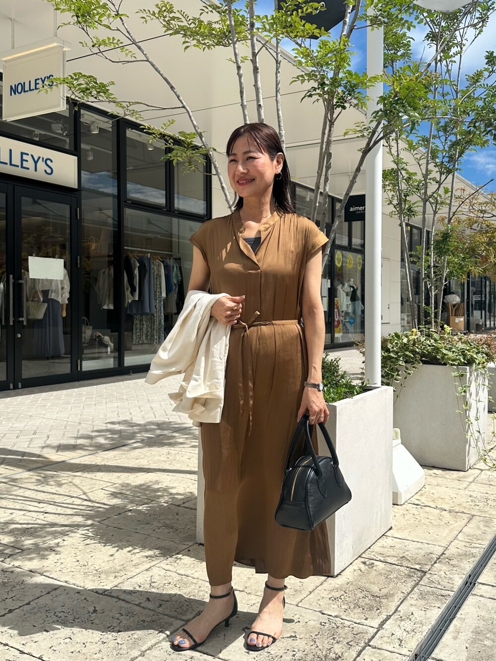 ブラウン系のワンピース、グレー系のTシャツ/カットソー、ホワイト系のテーラードジャケットを着用したレディースの夏コーディネートの10枚目の写真