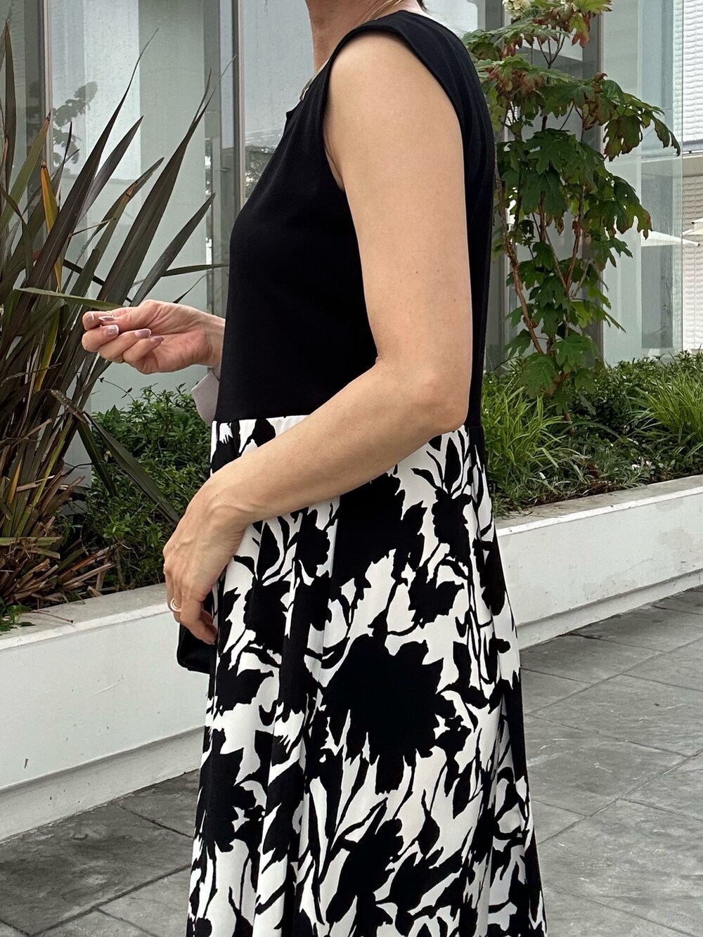 ホワイト系のワンピース、ブラック系のショルダーバッグ、ベージュ系のテーラードジャケットを着用したレディースの夏コーディネートの7枚目の写真