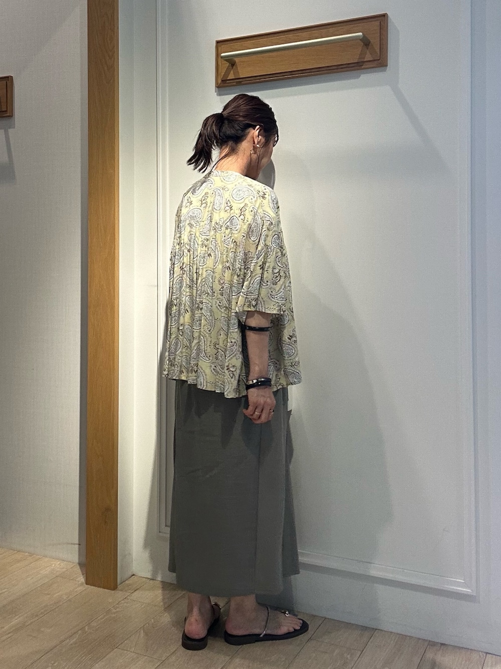 グリーン系のスカート、ブラウン系のシャツ/ブラウス、ホワイト系のシャツ/ブラウスを着用したレディースの夏コーディネートの3枚目の写真