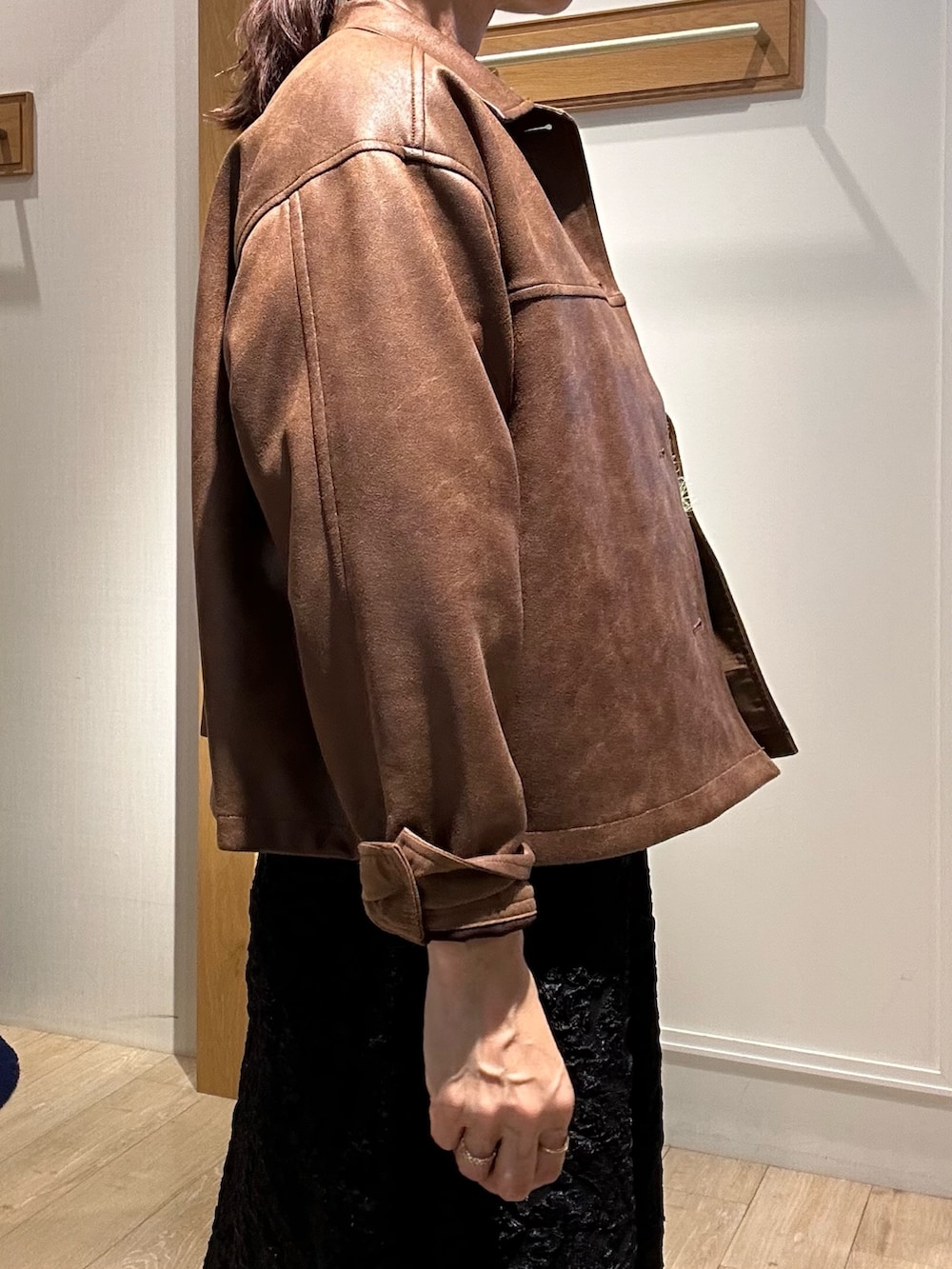 イエロー系のブルゾン、グリーン系のニット/セーター、グレー系のスカートを着用したレディースの秋コーディネートの6枚目の写真