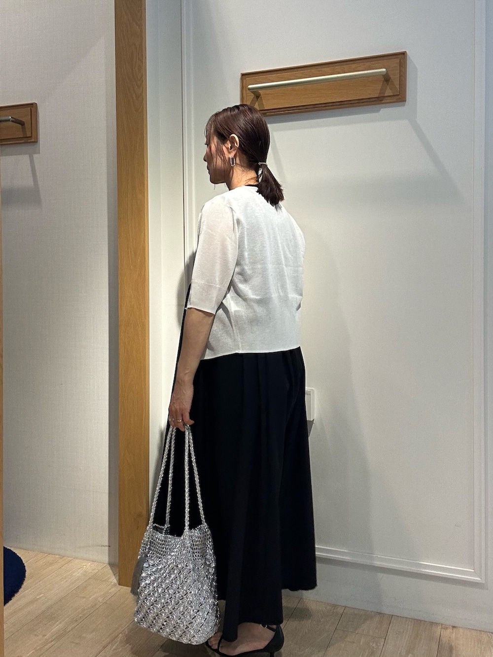 ホワイト系のニット/セーター、ブラック系のワンピース、ブラック系のサンダルを着用したレディースの夏コーディネートの4枚目の写真