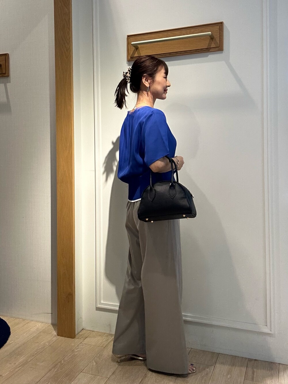 ブルー系のシャツ/ブラウス、ベージュ系のその他パンツ、ブラック系のボストンバッグを着用したレディースの夏コーディネートの4枚目の写真