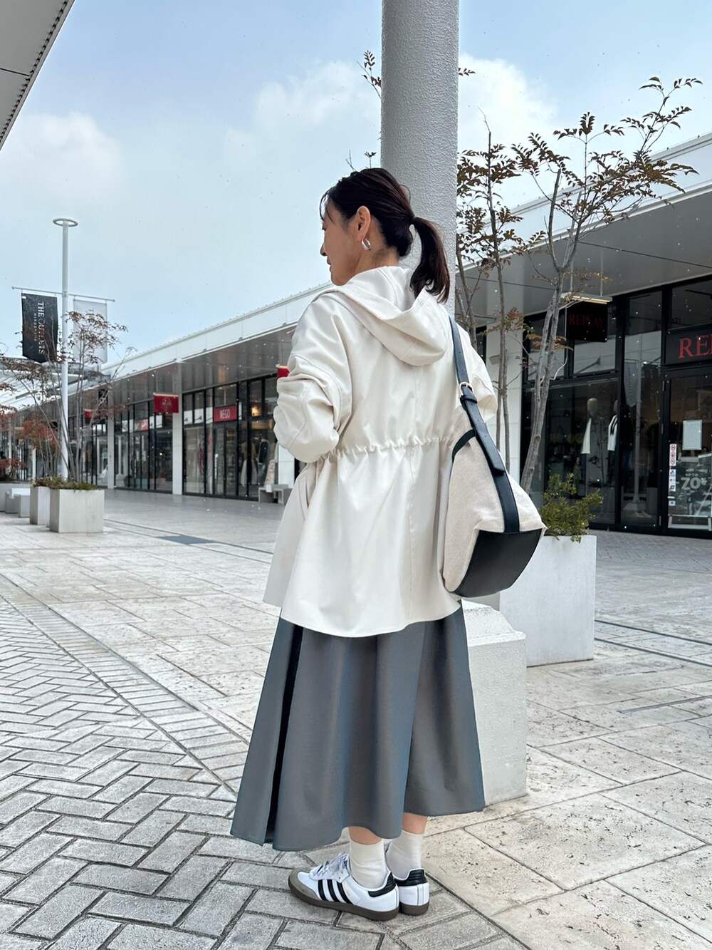 ホワイト系のブルゾン、イエロー系のシャツ/ブラウス、グリーン系のスカートを着用したレディースの冬コーディネートの3枚目の写真