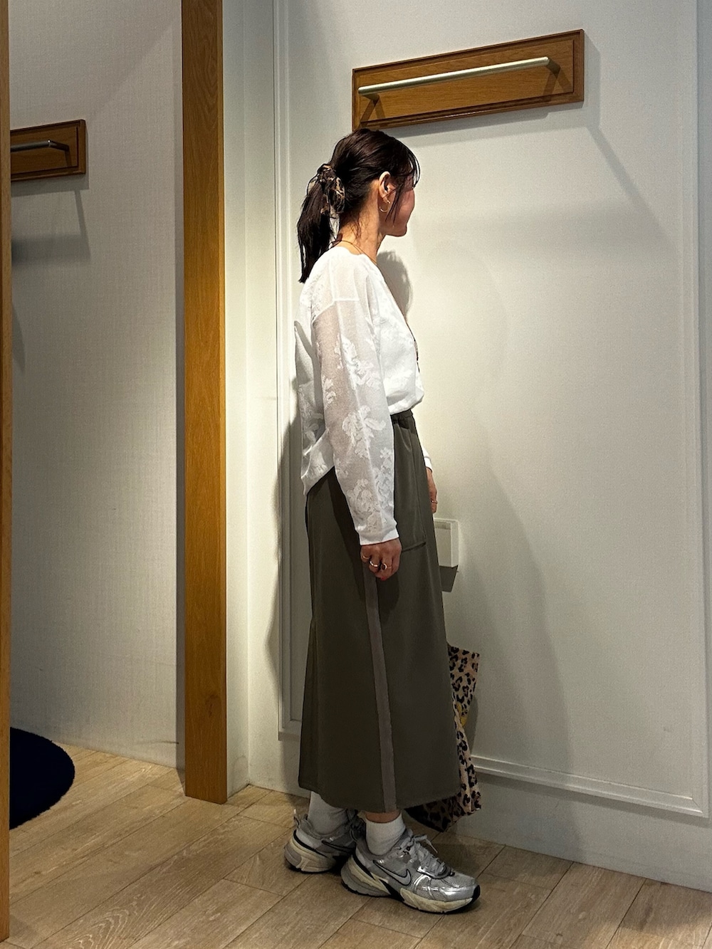 ホワイト系のニット/セーター、ホワイト系のTシャツ/カットソー、グリーン系のスカートを着用したレディースの春コーディネートの2枚目の写真