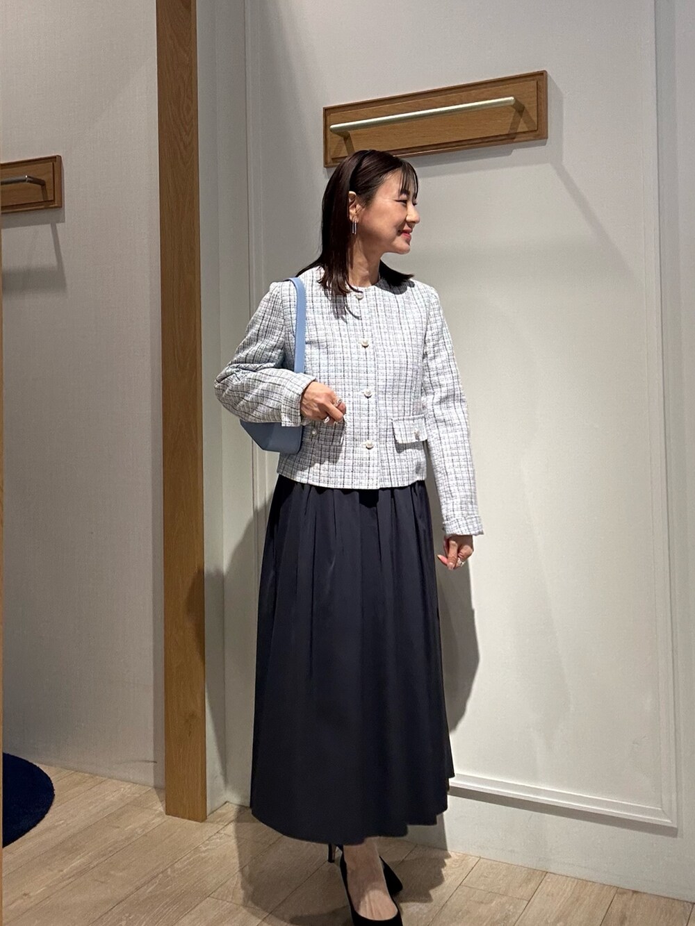 ホワイト系のノーカラージャケット、ブルー系のスカート、ホワイト系のTシャツ/カットソーを着用したレディースの冬コーディネートの3枚目の写真