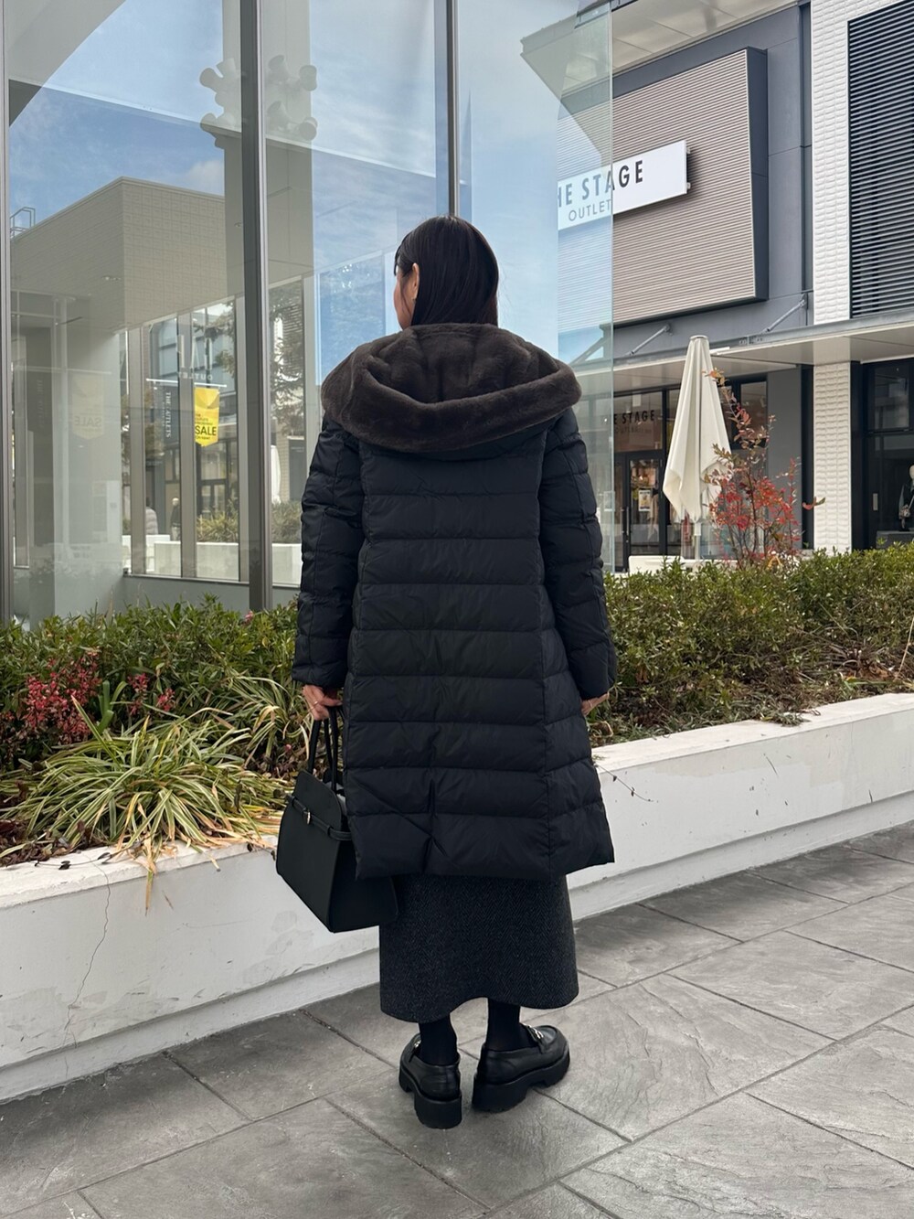 ブルー系のカーディガン/ボレロ、グレー系のスカート、ブラック系のトートバッグを着用したレディースの冬コーディネートの9枚目の写真