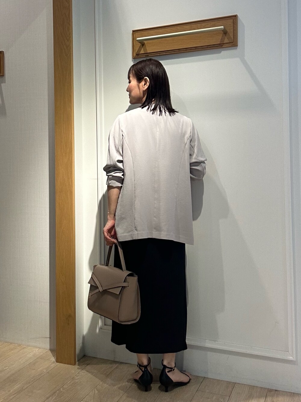 ブラック系のサンダル、ブラック系のシャツ/ブラウス、ベージュ系のノーカラージャケットを着用したレディースの夏コーディネートの3枚目の写真