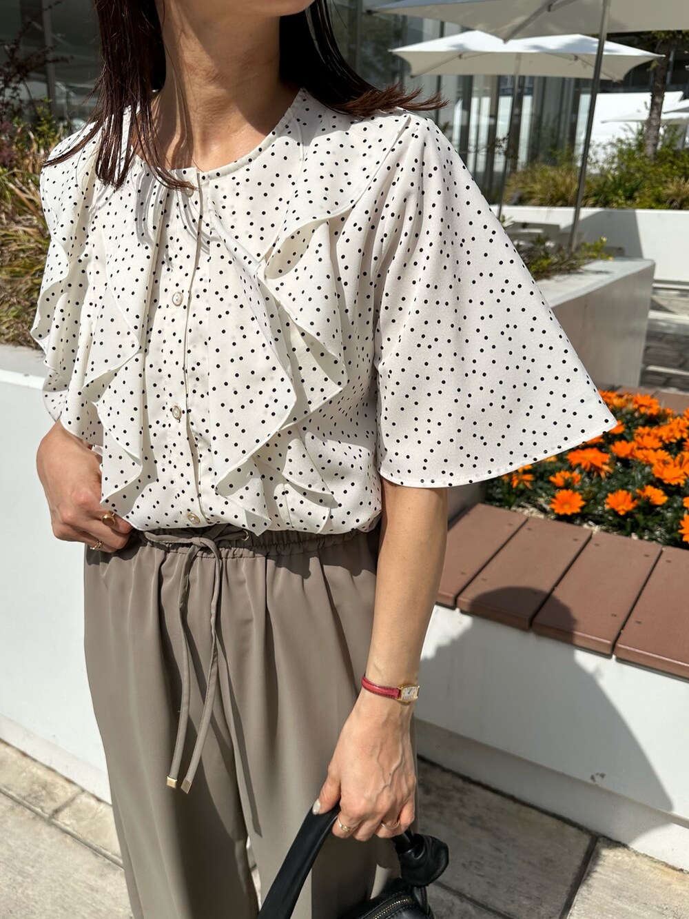 ホワイト系のシャツ/ブラウス、グリーン系のその他パンツ、ブラック系のショルダーバッグを着用したレディースの春コーディネートの6枚目の写真