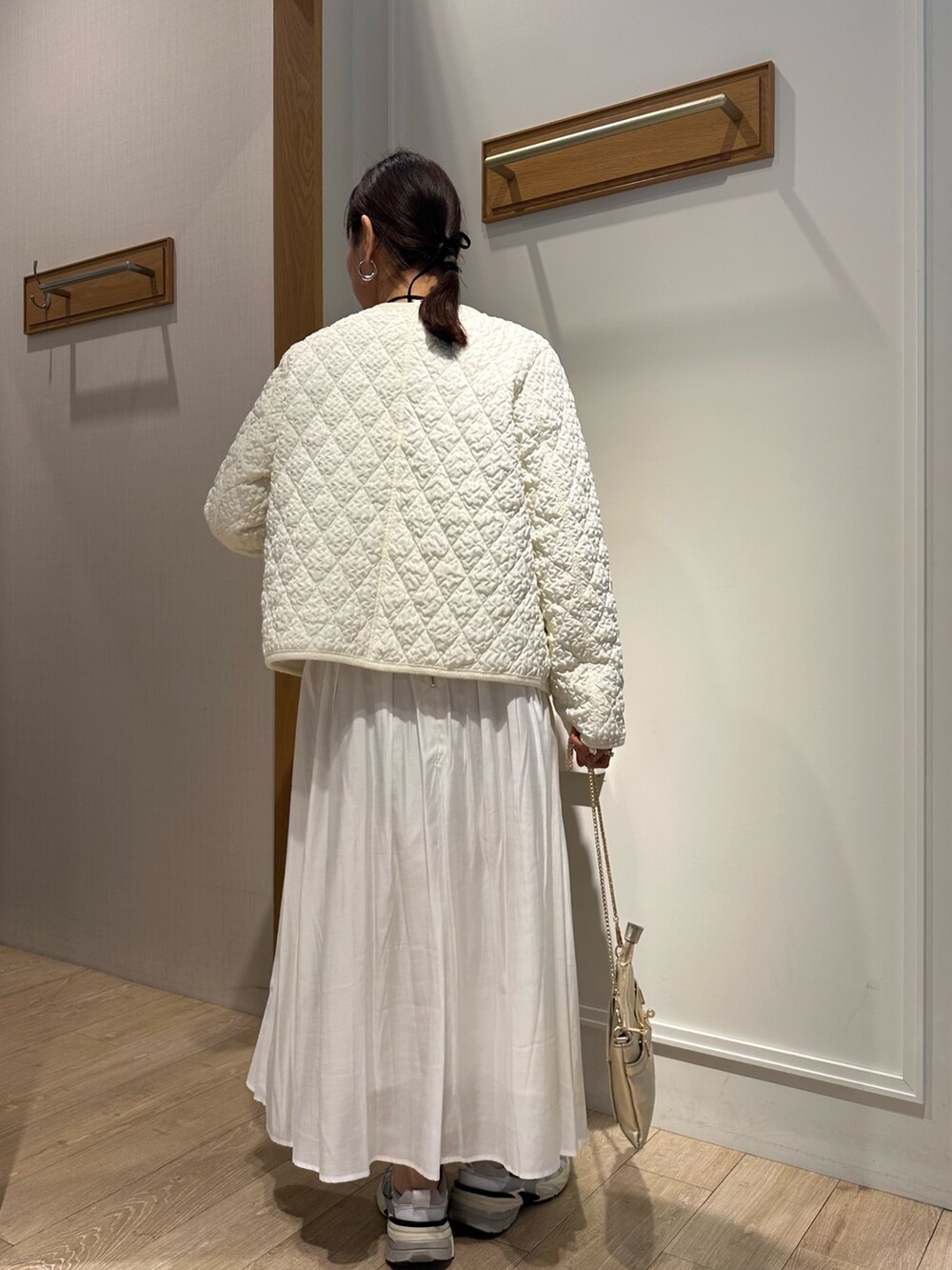 ホワイト系のブルゾン、ブルー系のニット/セーター、ホワイト系のスカートを着用したレディースの冬コーディネートの3枚目の写真