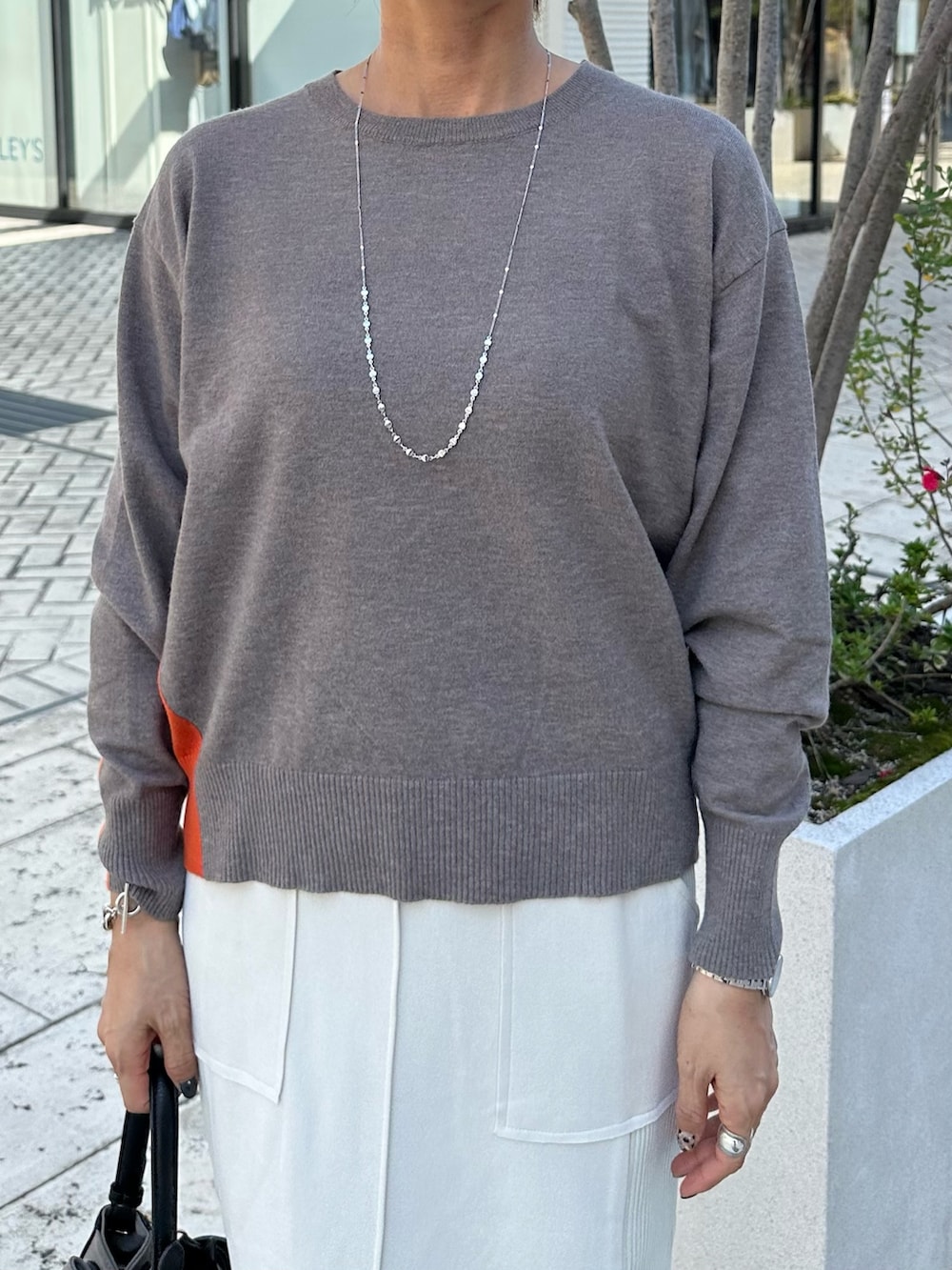 ブラウン系のニット/セーター、グレー系のスカート、ブラウン系のブルゾンを着用したレディースの秋コーディネートの5枚目の写真