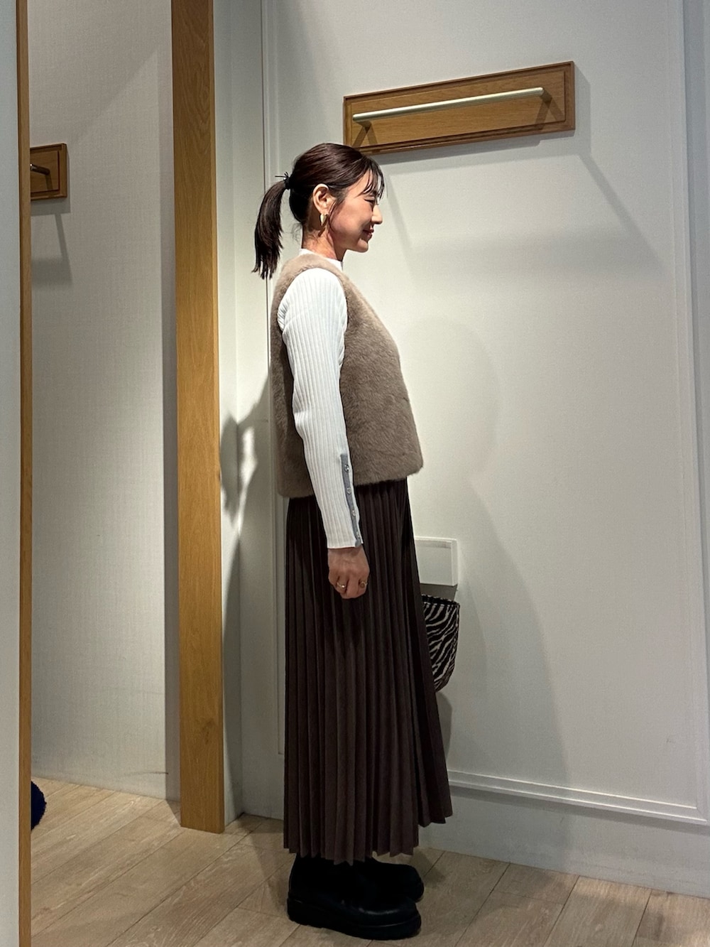 ホワイト系のニット/セーター、ブラウン系のスカート、ブラウン系のブルゾンを着用したレディースの秋コーディネートの2枚目の写真