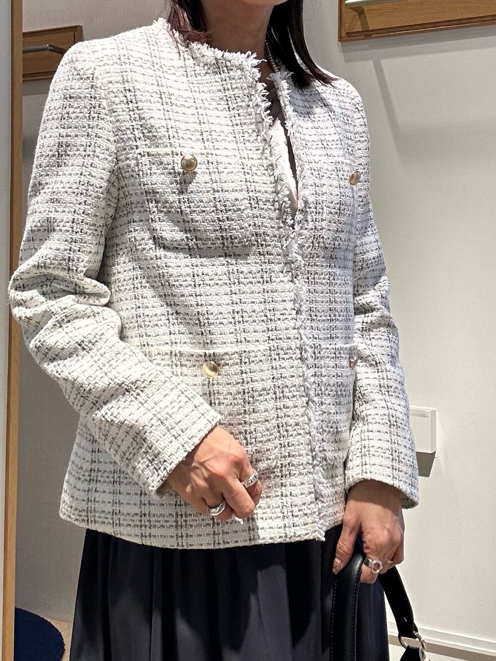 ホワイト系のノーカラージャケット、ブルー系のスカートを着用したレディースの冬コーディネートの4枚目の写真