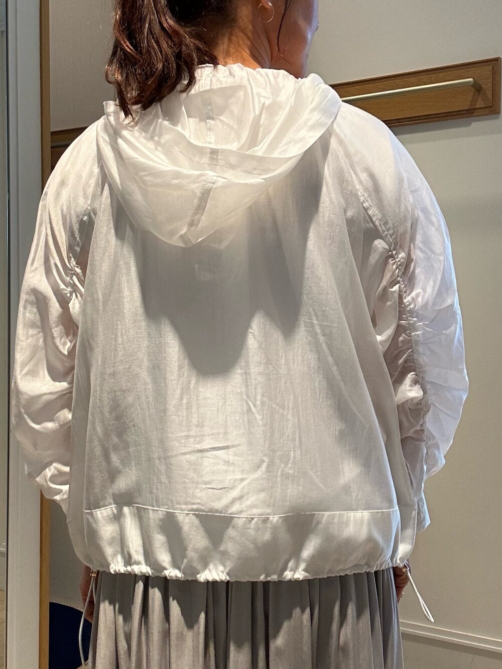 ベージュ系のスカート、ホワイト系のブルゾン、ホワイト系のTシャツ/カットソーを着用したレディースの春コーディネートの6枚目の写真