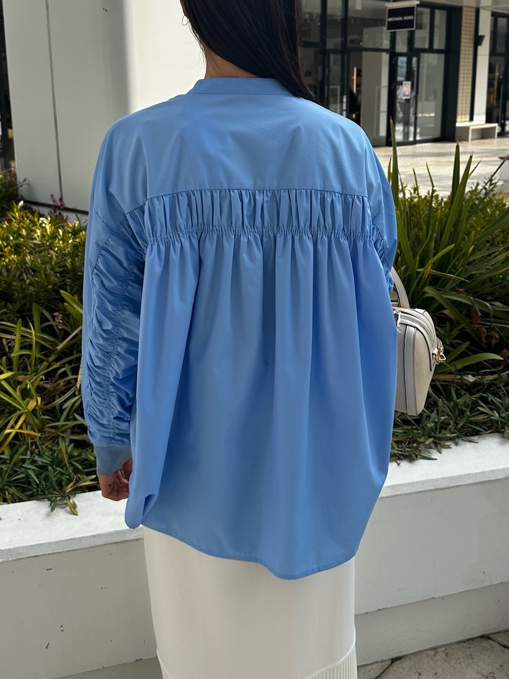 ホワイト系のパーカー、ブルー系のシャツ/ブラウス、ホワイト系のスカートを着用したレディースの冬コーディネートの9枚目の写真