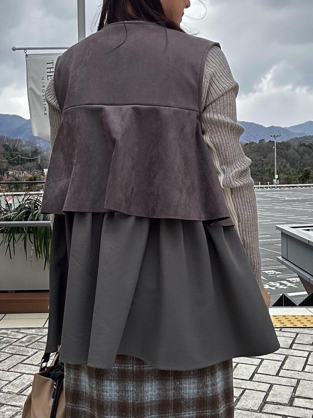 グレー系のブルゾン、グレー系のその他パンツ、ホワイト系のニット/セーターを着用したレディースの冬コーディネートの10枚目の写真