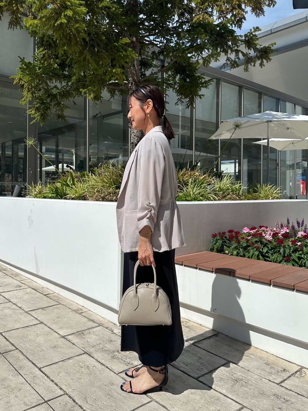 ブラック系のシャツ/ブラウス、ブラック系のスカート、ベージュ系のボストンバッグを着用したレディースの夏コーディネートの9枚目の写真