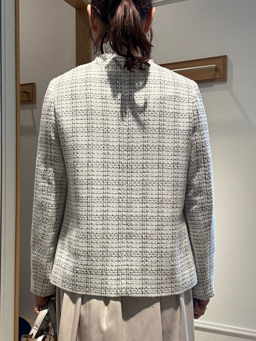 ホワイト系のノーカラージャケット、ベージュ系のスカート、ホワイト系のTシャツ/カットソーを着用したレディースの冬コーディネートの6枚目の写真