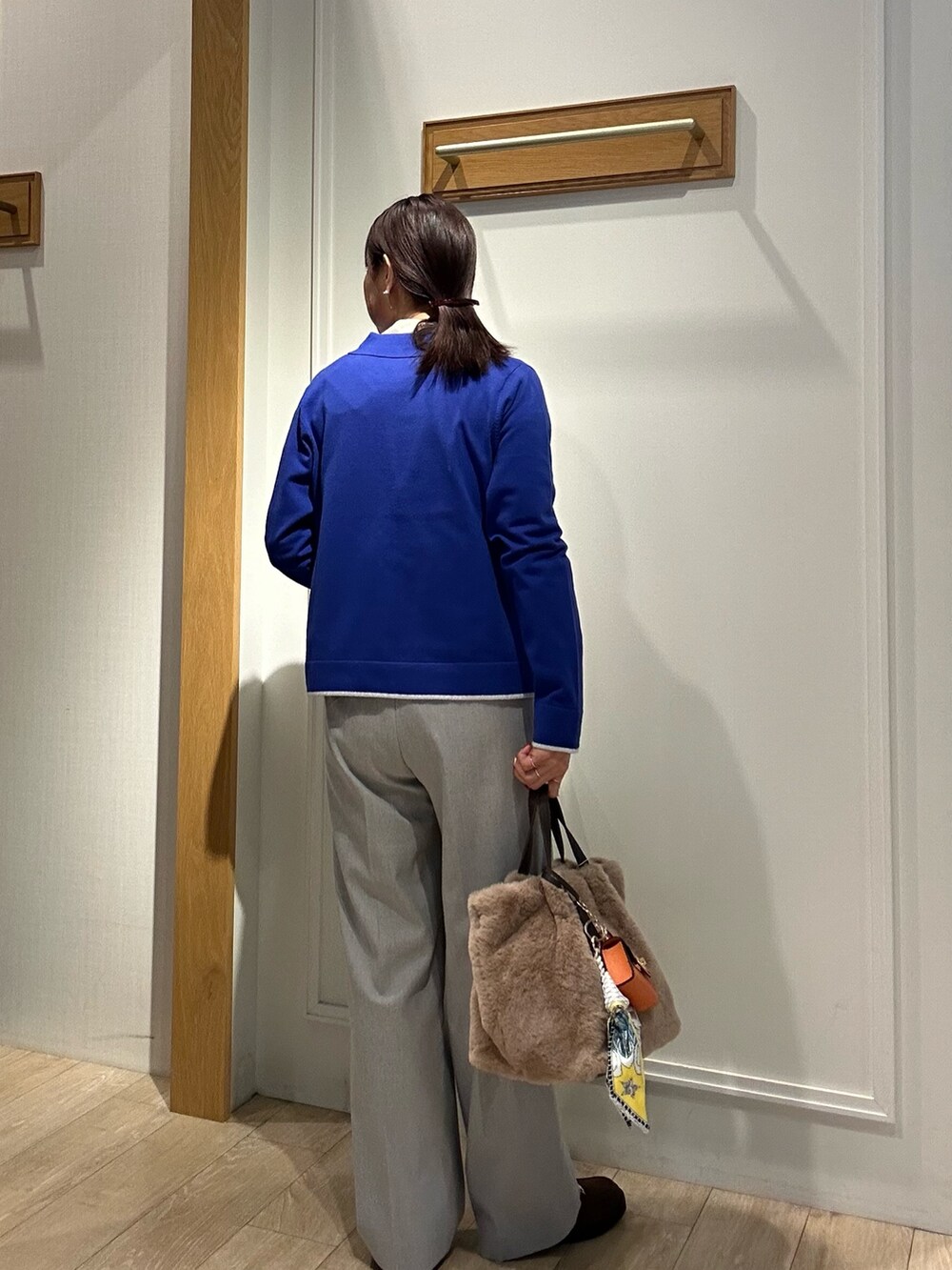 ブラウン系のローファー、ブラック系のダウンジャケット/コート、ブルー系のカーディガン/ボレロを着用したレディースの冬コーディネートの7枚目の写真