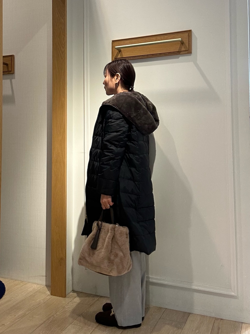 ブラウン系のローファー、ブラック系のダウンジャケット/コート、ブルー系のカーディガン/ボレロを着用したレディースの冬コーディネートの2枚目の写真