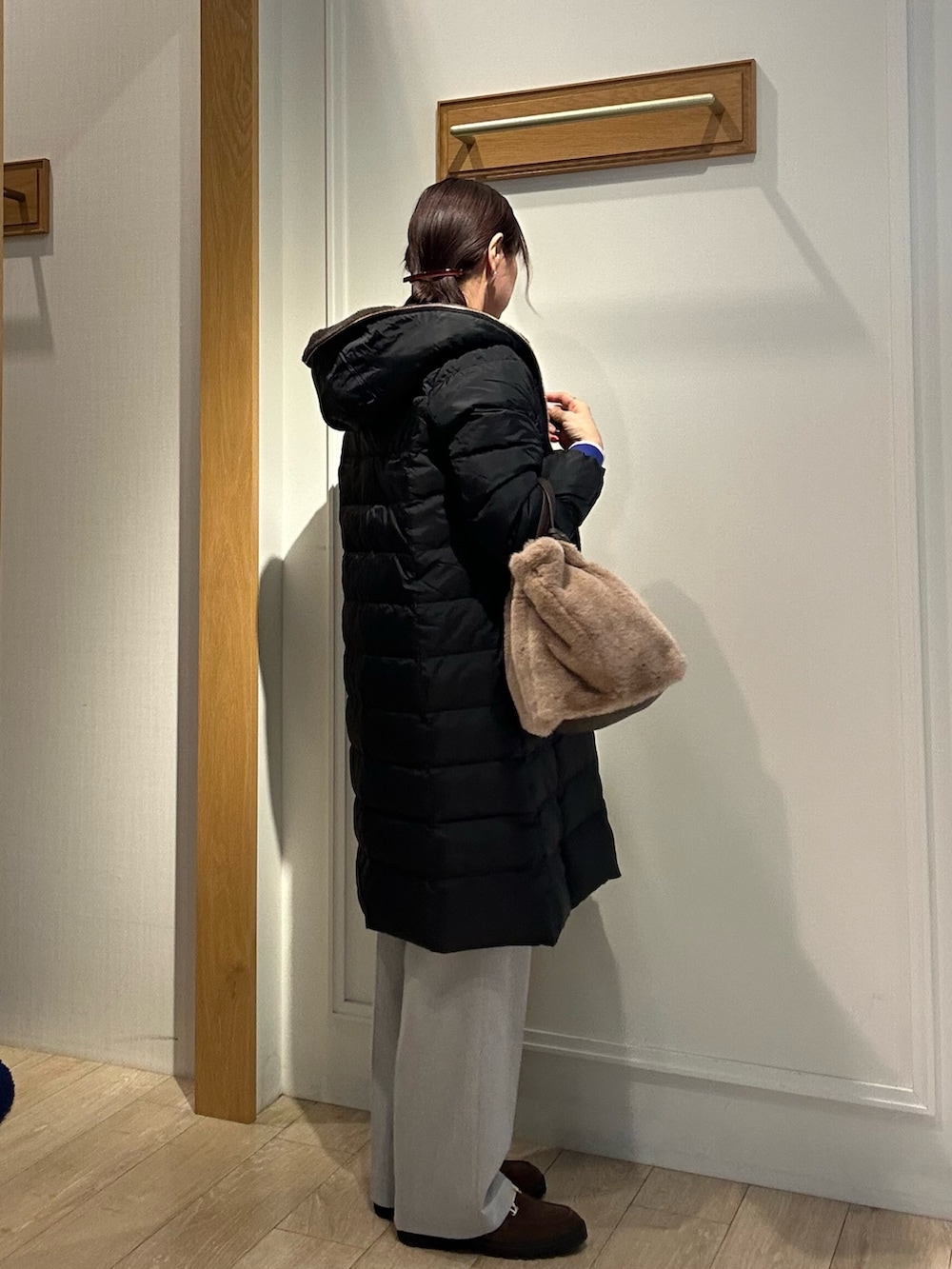 ブラウン系のローファー、ブラック系のダウンジャケット/コート、ブルー系のカーディガン/ボレロを着用したレディースの冬コーディネートの4枚目の写真