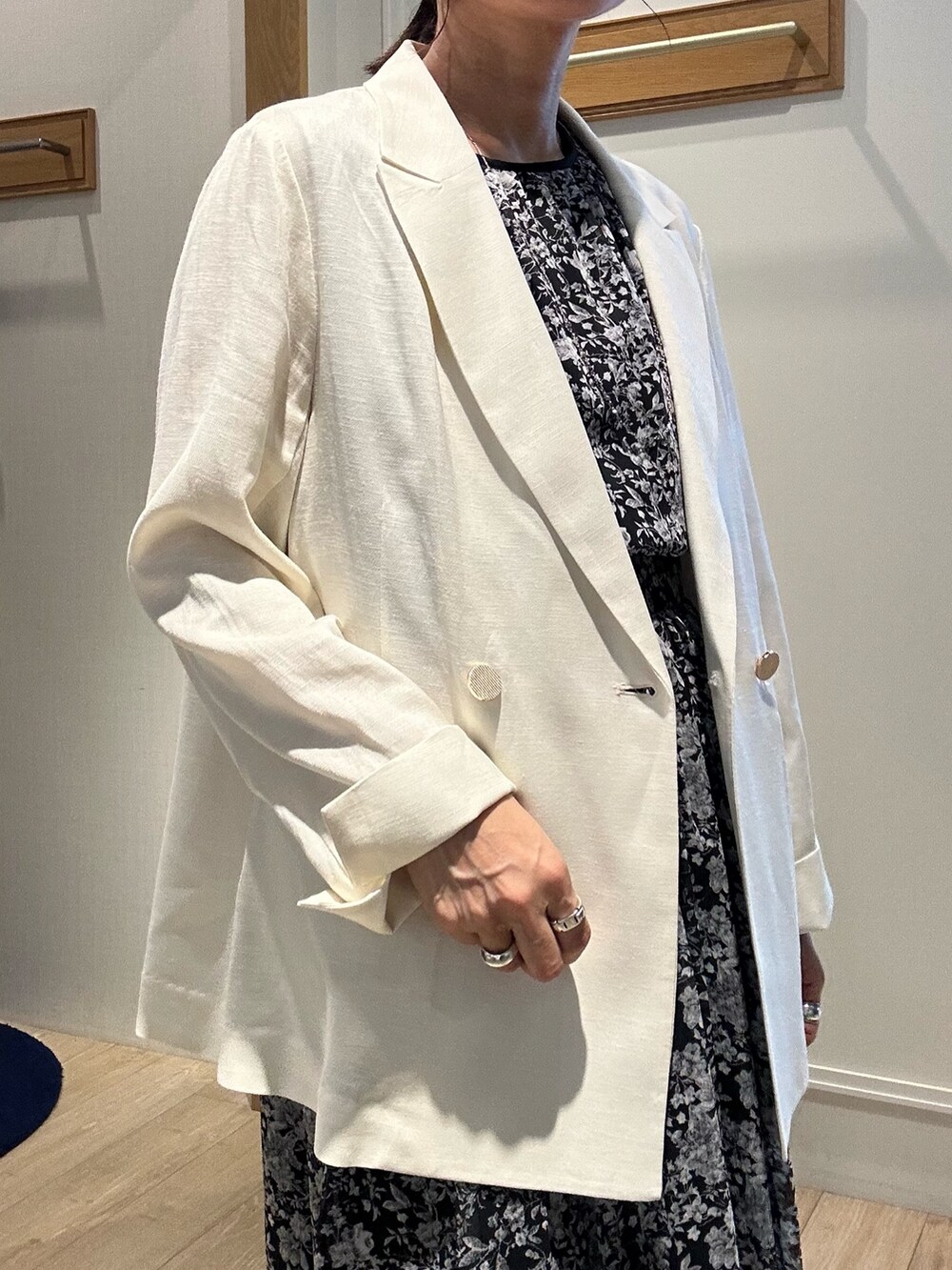 ブラック系のワンピース、ホワイト系のテーラードジャケット、ブラック系のショルダーバッグを着用したレディースの夏コーディネートの6枚目の写真