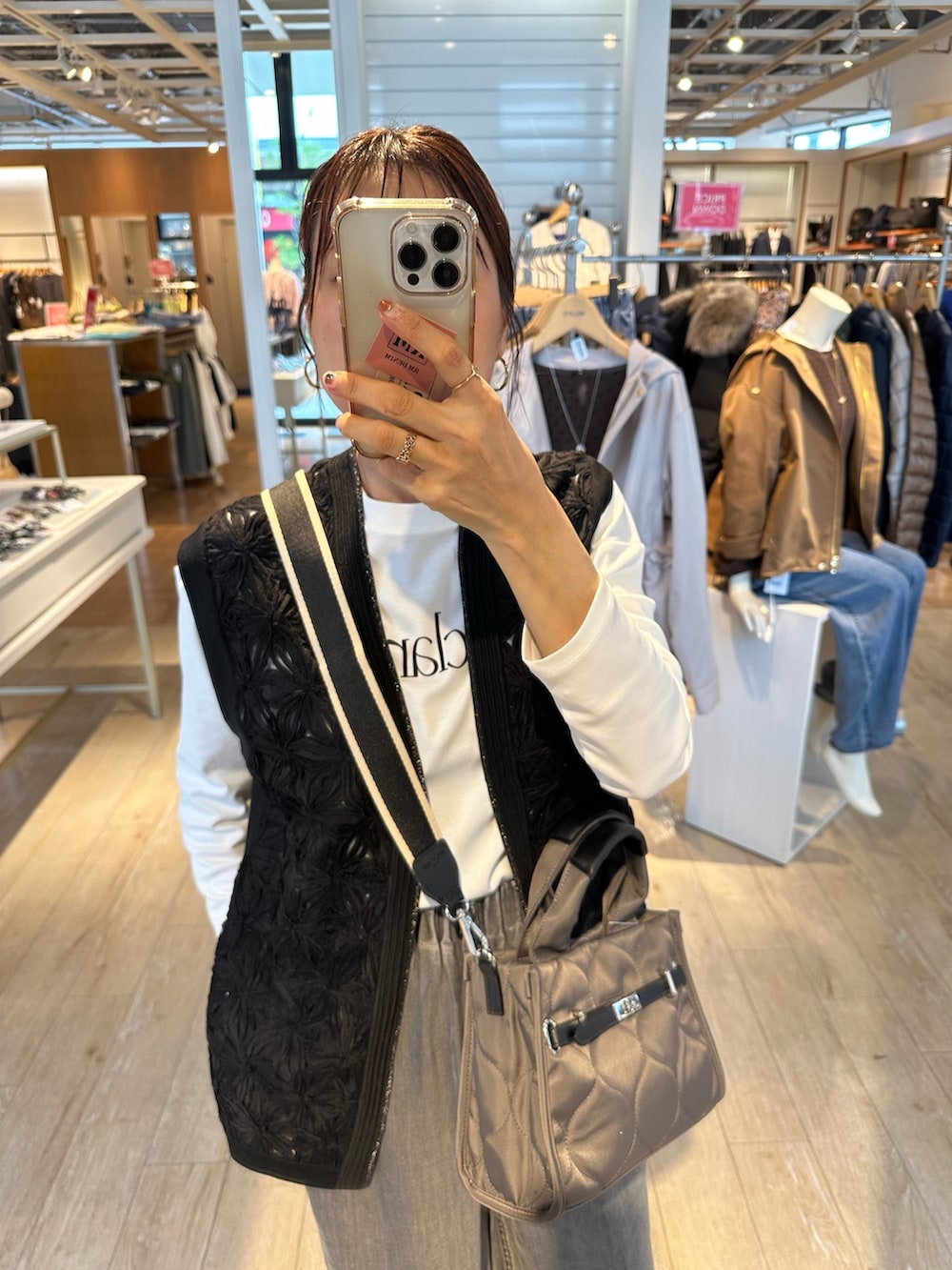 グレー系のデニムパンツ、ブラック系のニット/セーター、グレー系のトートバッグを着用したレディースの秋コーディネートの9枚目の写真