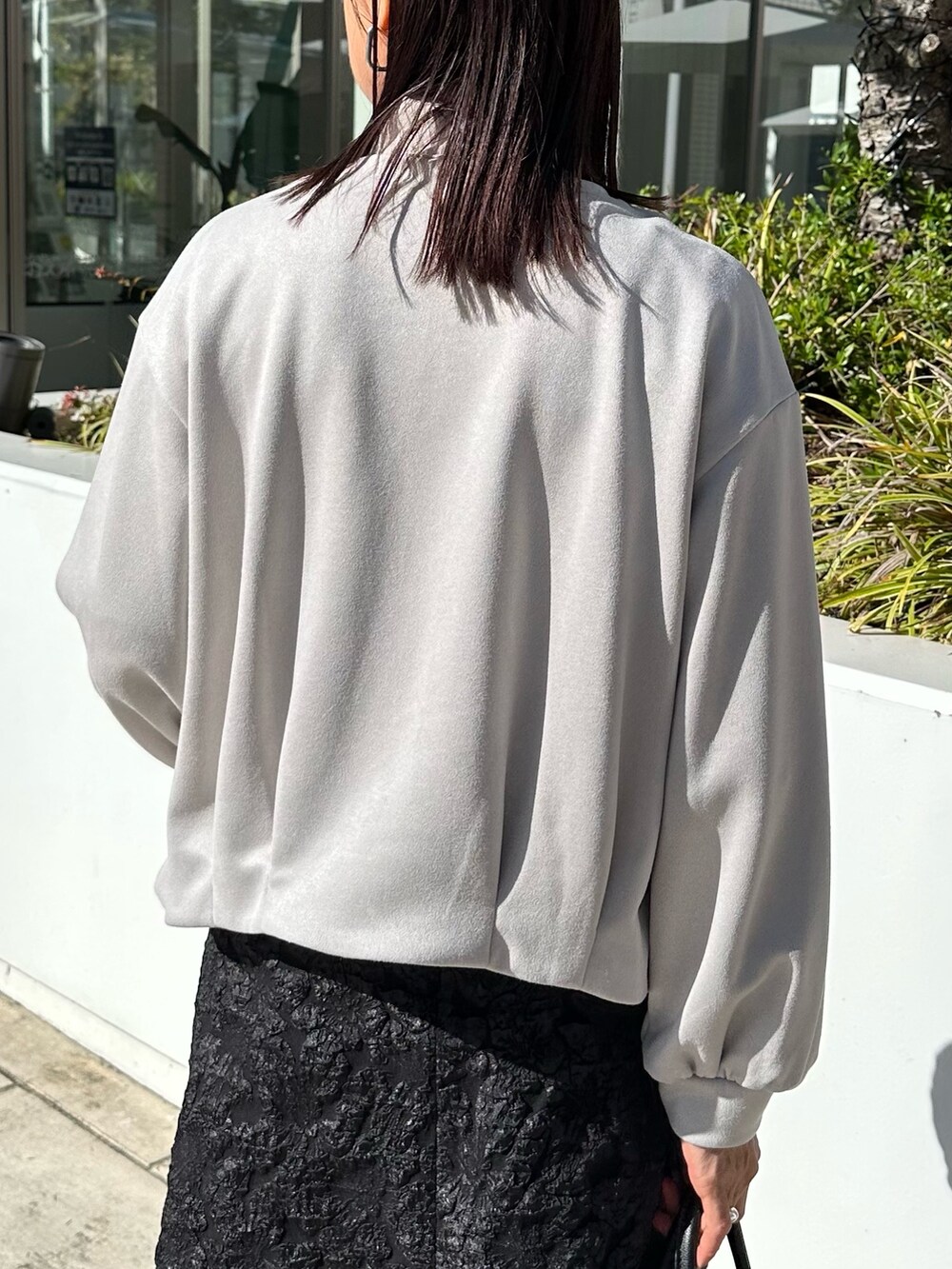 グレー系のブルゾン、ブラック系のニット/セーター、グレー系のスカートを着用したレディースの秋コーディネートの8枚目の写真