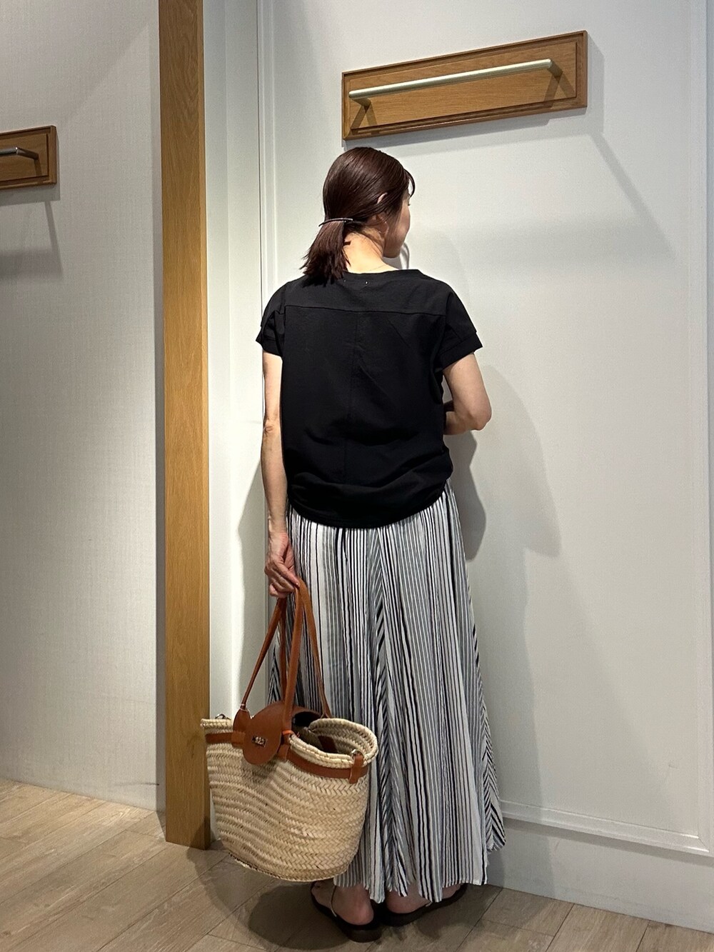 ブラック系のTシャツ/カットソー、グレー系のスカートを着用したレディースの夏コーディネートの3枚目の写真