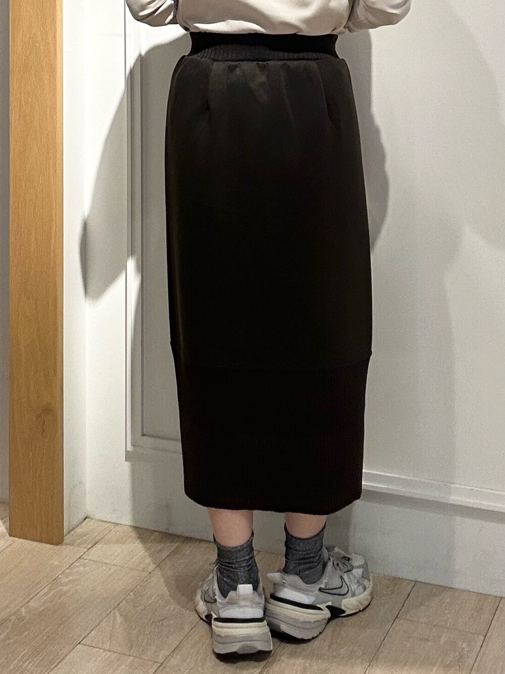 ブラウン系のパーカー、ブラウン系のスカート、ブラック系のショルダーバッグを着用したレディースの秋コーディネートの9枚目の写真