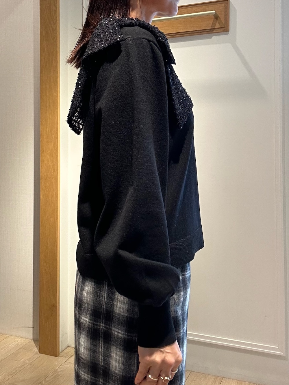 ブラック系のニット/セーター、ブルー系のスカート、ホワイト系のトートバッグを着用したレディースの冬コーディネートの6枚目の写真